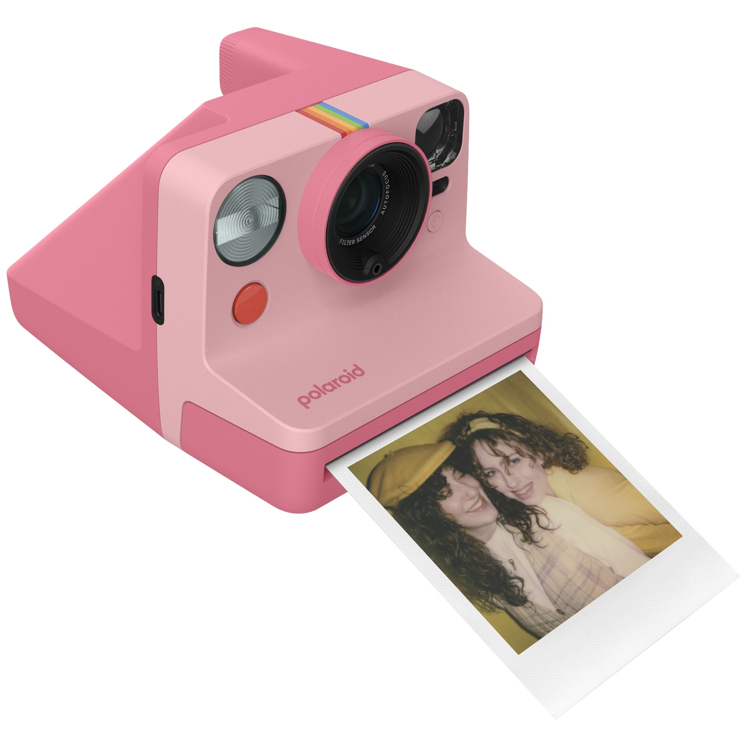 Roze Polaroid camera die een foto van twee lachende vrouwen met krullend haar uitwerpt.
