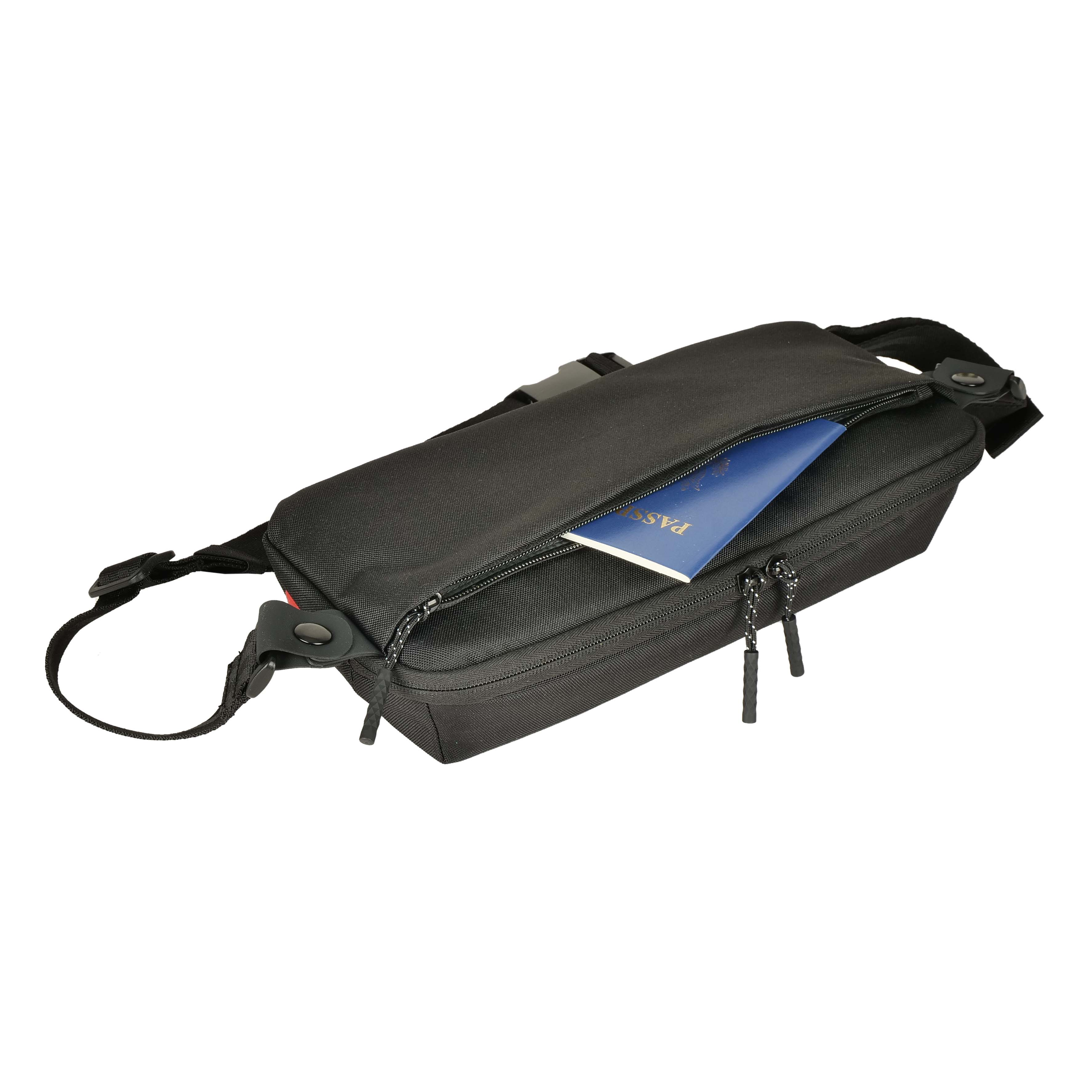 Eine schwarze Bauchtasche mit offenem Fach und einem blauen Reisepass.