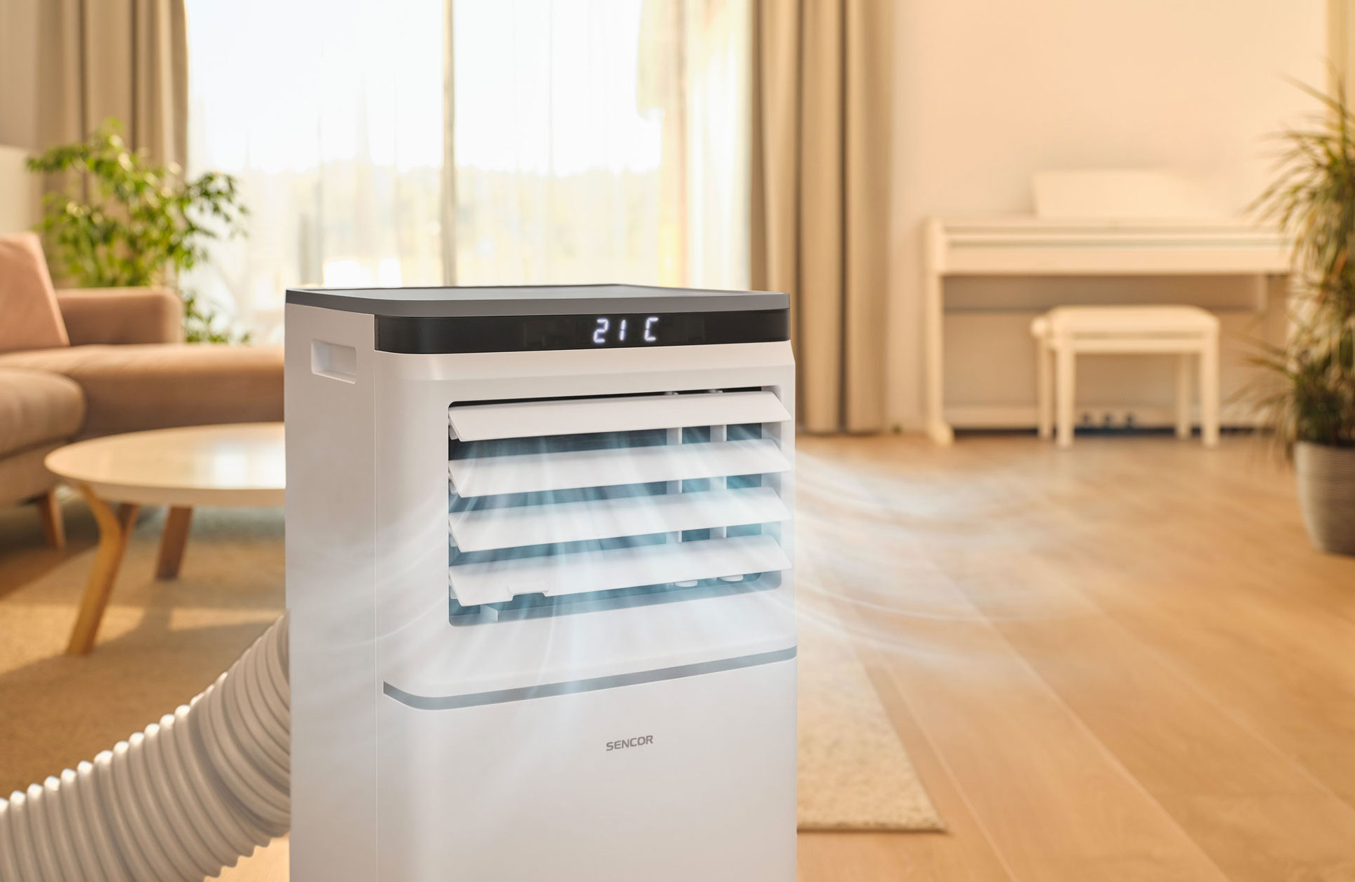 Biała przenośna klimatyzacja z cyfrowym wyświetlaczem w salonie.