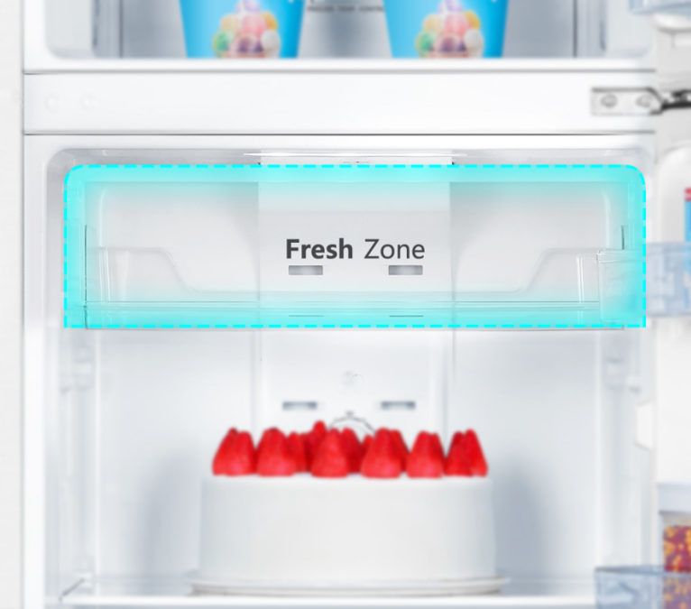 Interior de refrigerador con cajón "Fresh Zone" y pastel de fresas.