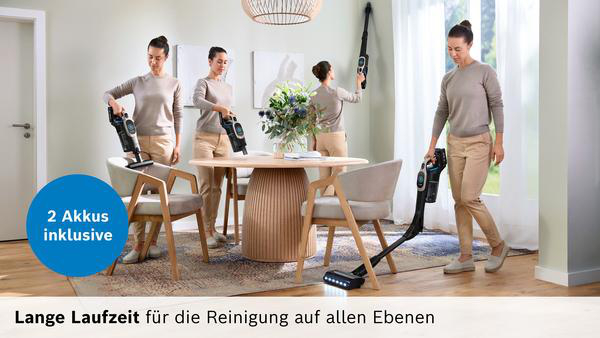 Frau benutzt Akku-Staubsauger in einem Esszimmer. Zwei Akkus inklusive.