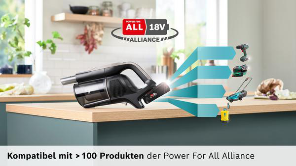Schwarzer Akku-Staubsauger mit Akku auf einer Arbeitsplatte, daneben Werkzeuge.