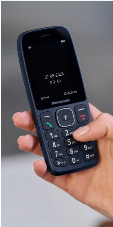 Dłoń trzyma niebieski telefon Panasonic z klawiaturą i datą/godziną.