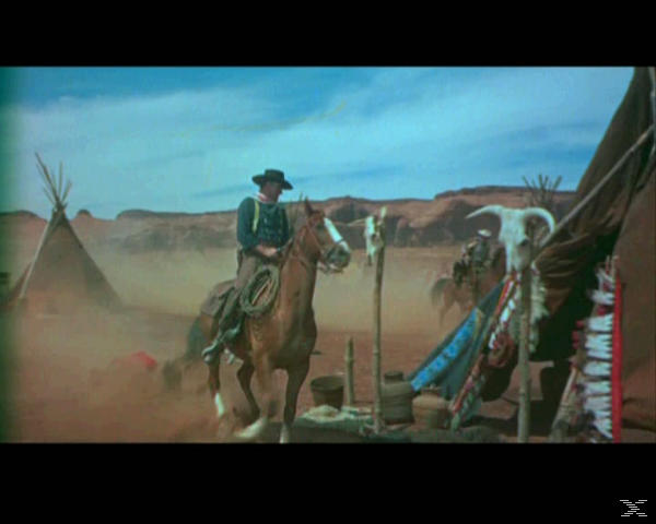 Ein Reiter auf einem Pferd in einer staubigen Wüstenlandschaft mit Tipis und Totenschädeln.