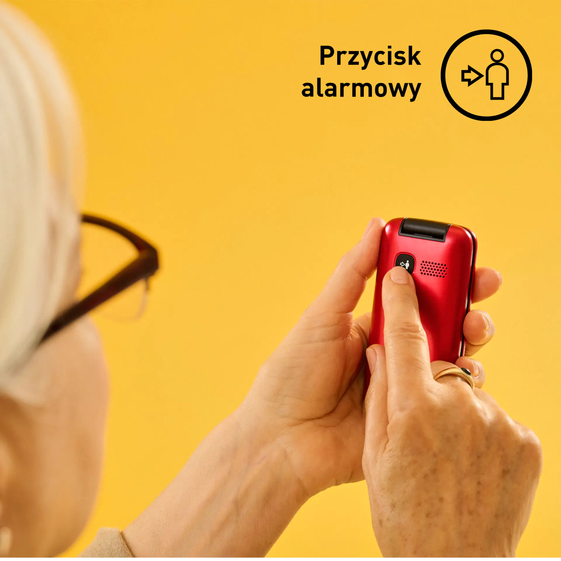 Osoba naciska czerwony przycisk na telefonie komórkowym. Żółte tło.