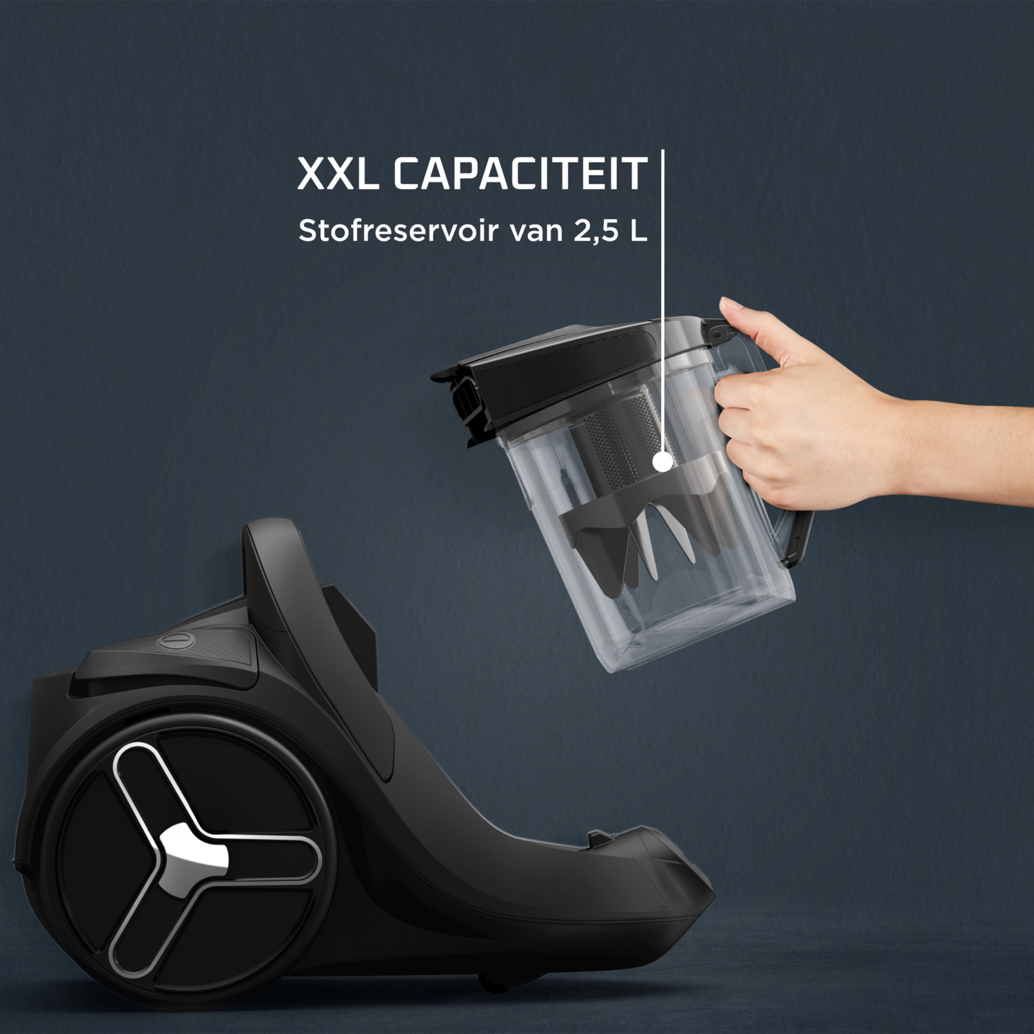 Hand houdt zwarte stofzuigerbak met XXL capaciteit 2,5 L.