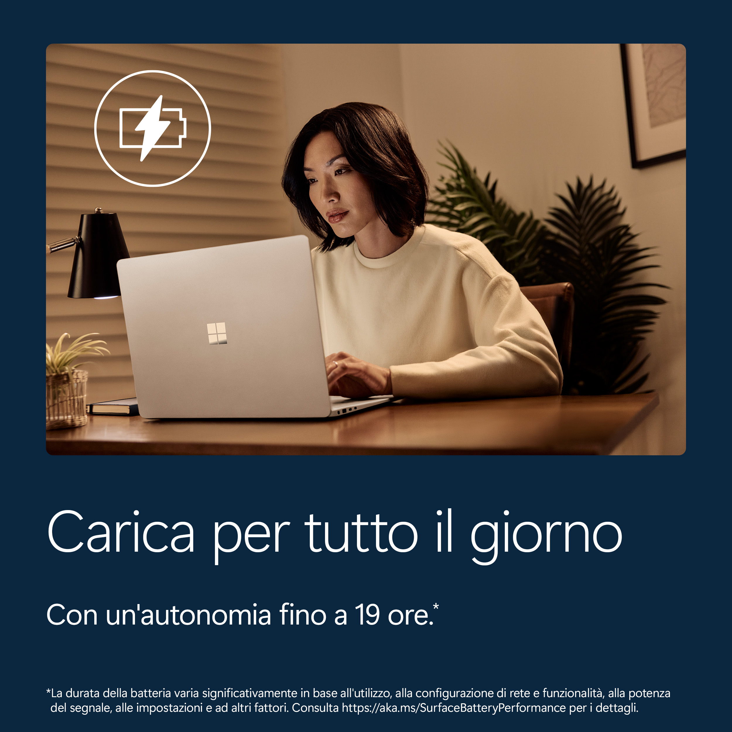 Una donna lavora su un laptop. È visibile un'icona della batteria.