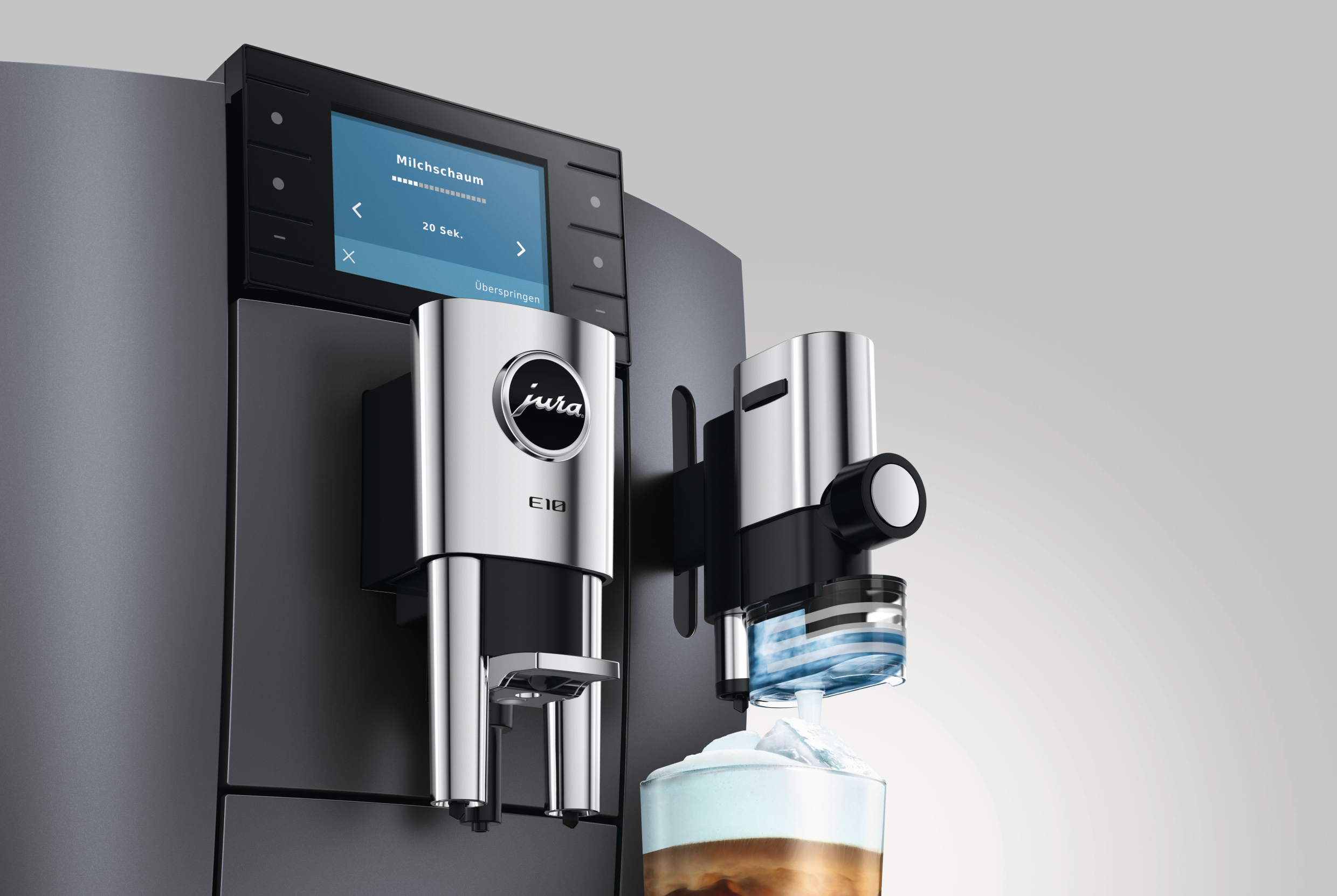 Kaffeemaschine mit Milchaufschäumer und einem Glas Kaffee mit Milchschaum.
