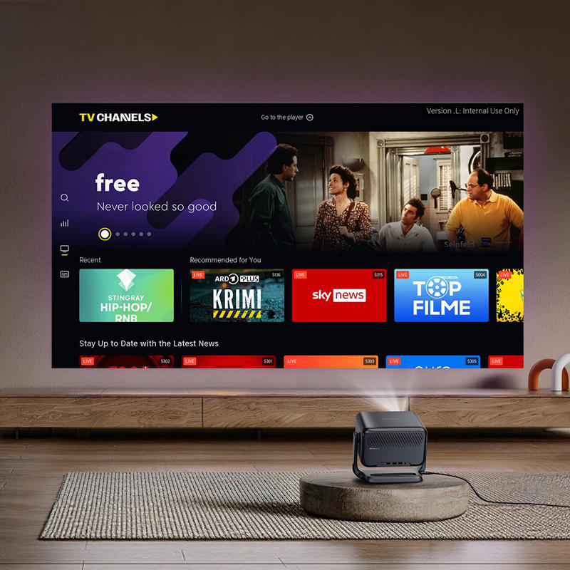 Ein Heimkino-Setup mit einem Projektor, der auf einen großen Bildschirm zeigt. Der Bildschirm zeigt eine TV-Oberfläche mit Kanälen.