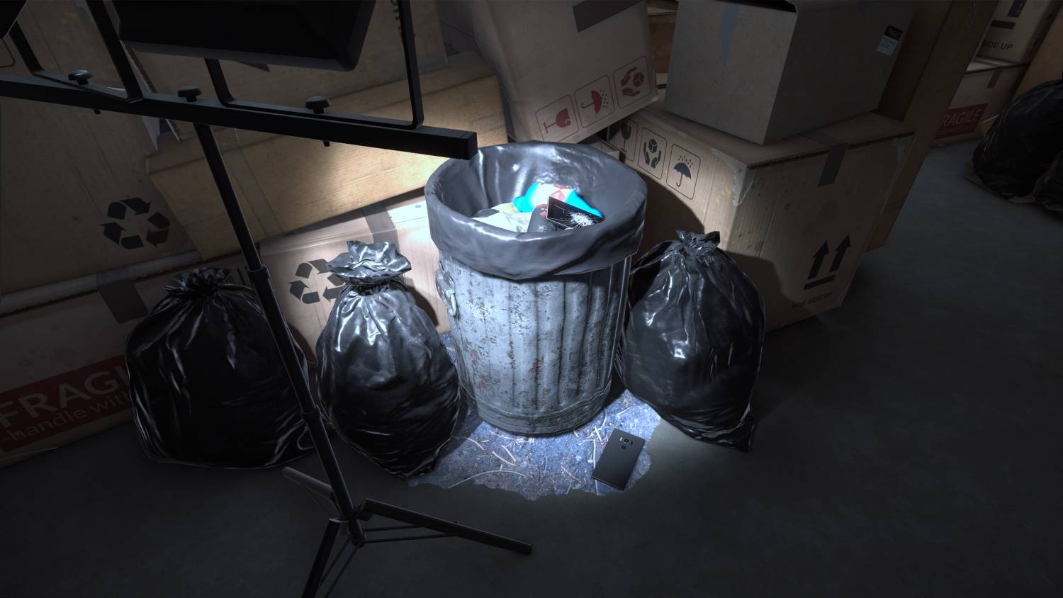 Un cubo de basura con bolsas de basura y cajas. Un teléfono está delante.