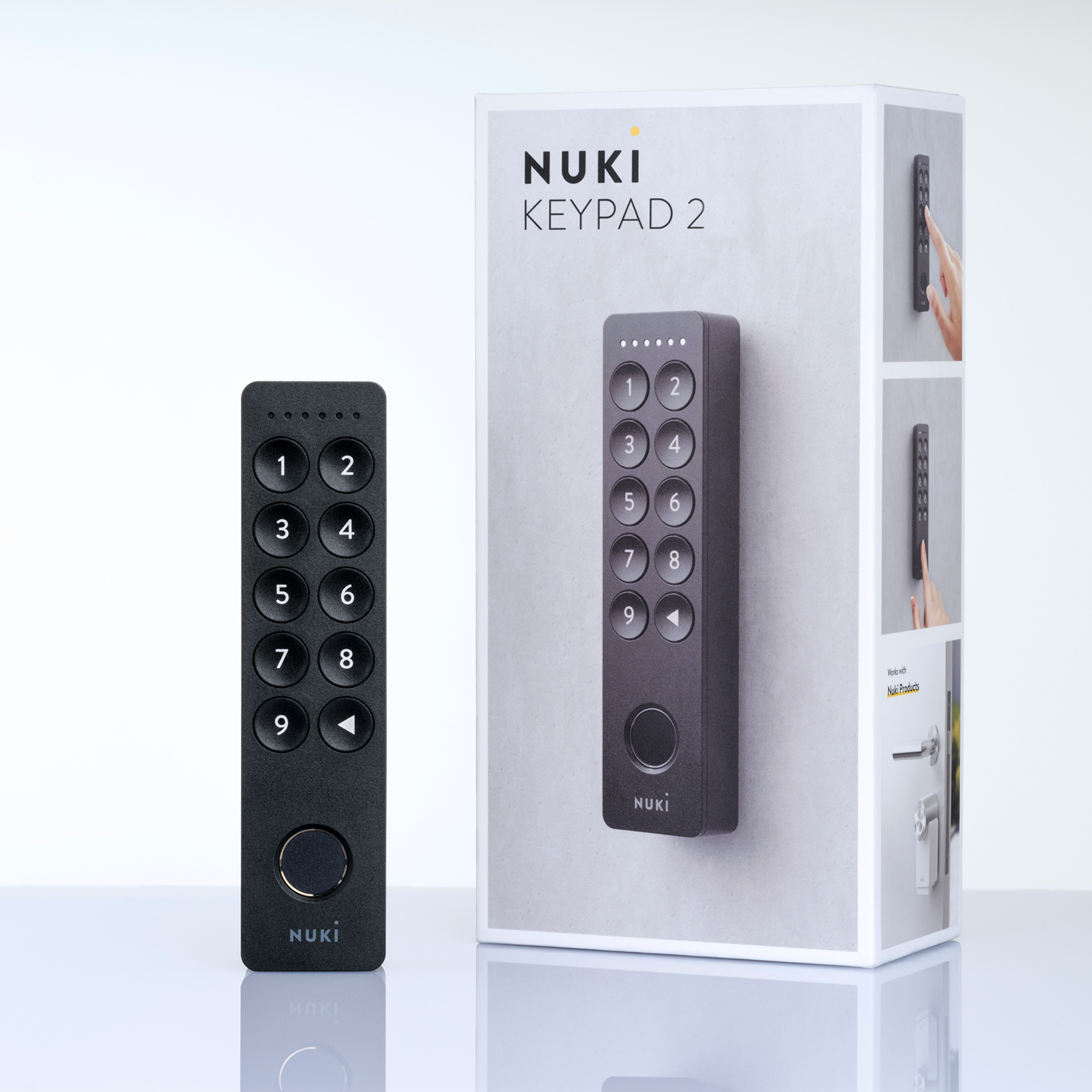 Egy fekete Nuki Keypad 2 és a csomagolása egymás mellett áll.