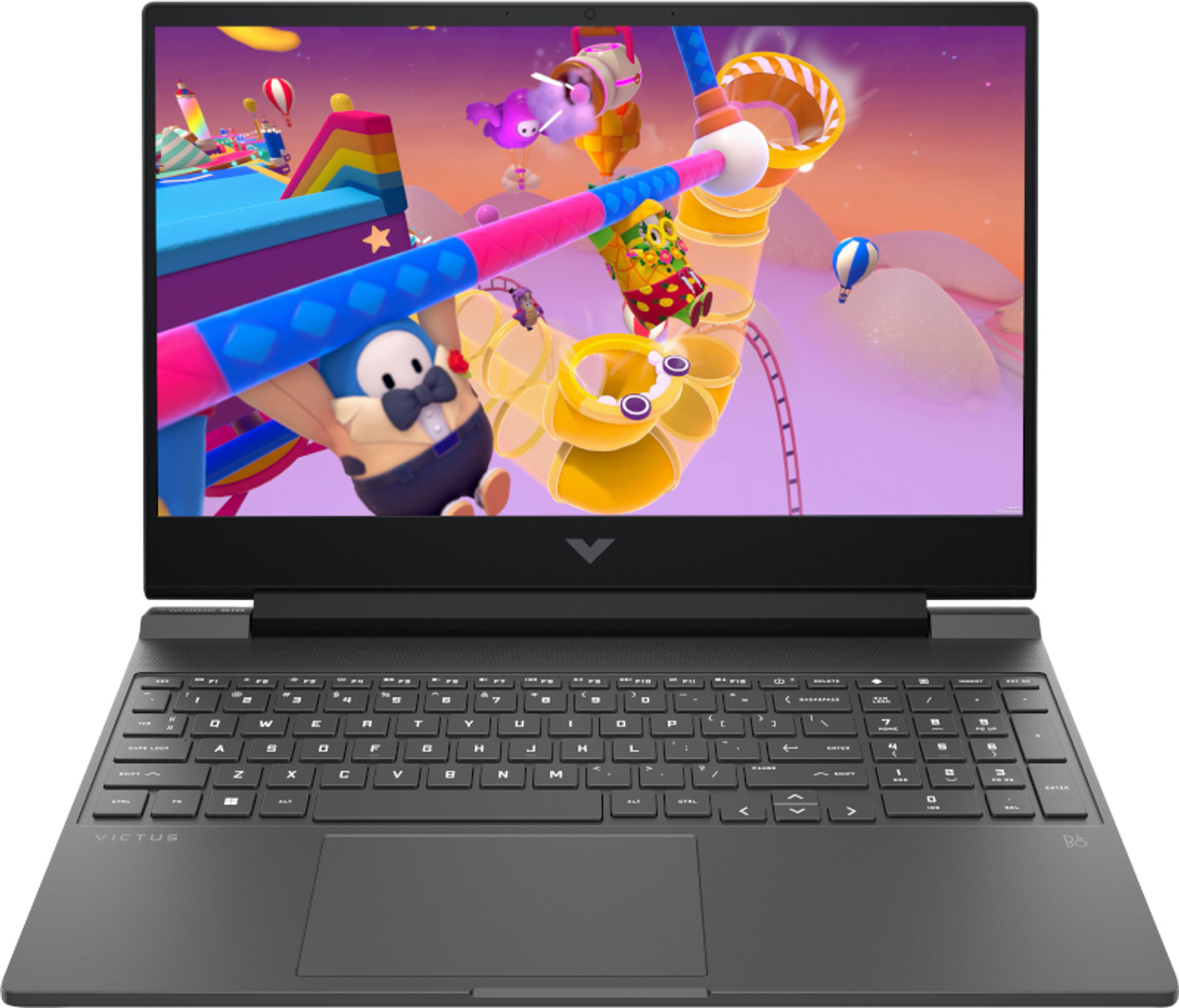 Laptop wyświetla kolorową grę Fall Guys z postaciami i przeszkodami.