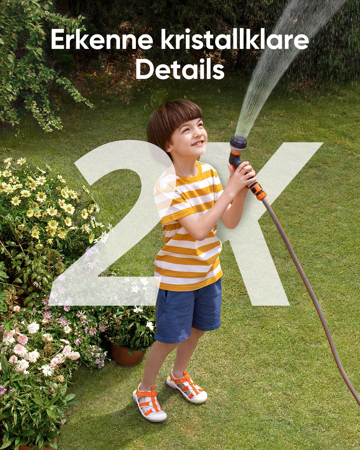 Ein Junge mit einem gestreiften T-Shirt und blauen Shorts gießt Pflanzen mit einem Gartenschlauch.