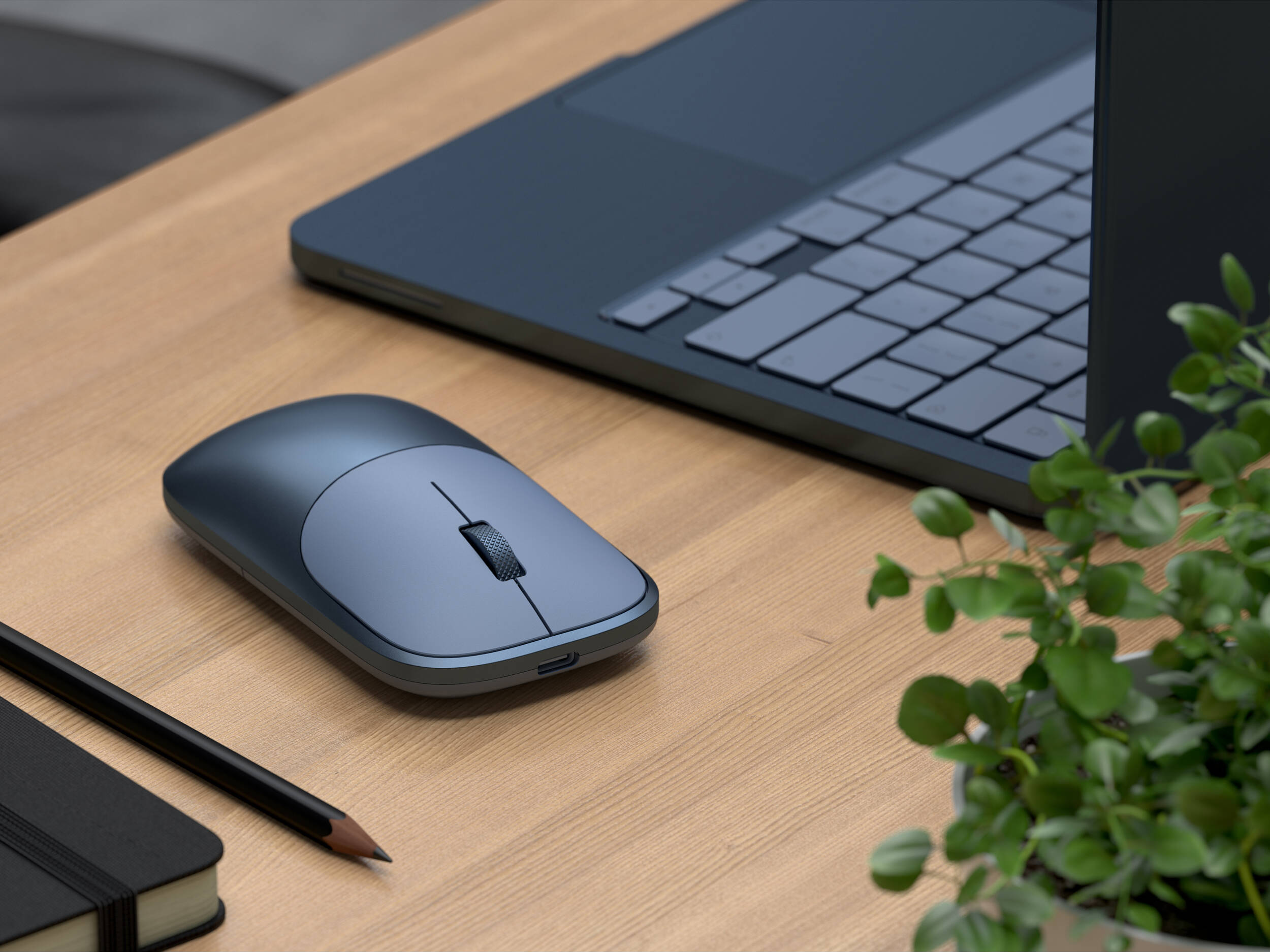 Souris grise, ordinateur portable, carnet et crayon sur un bureau en bois.