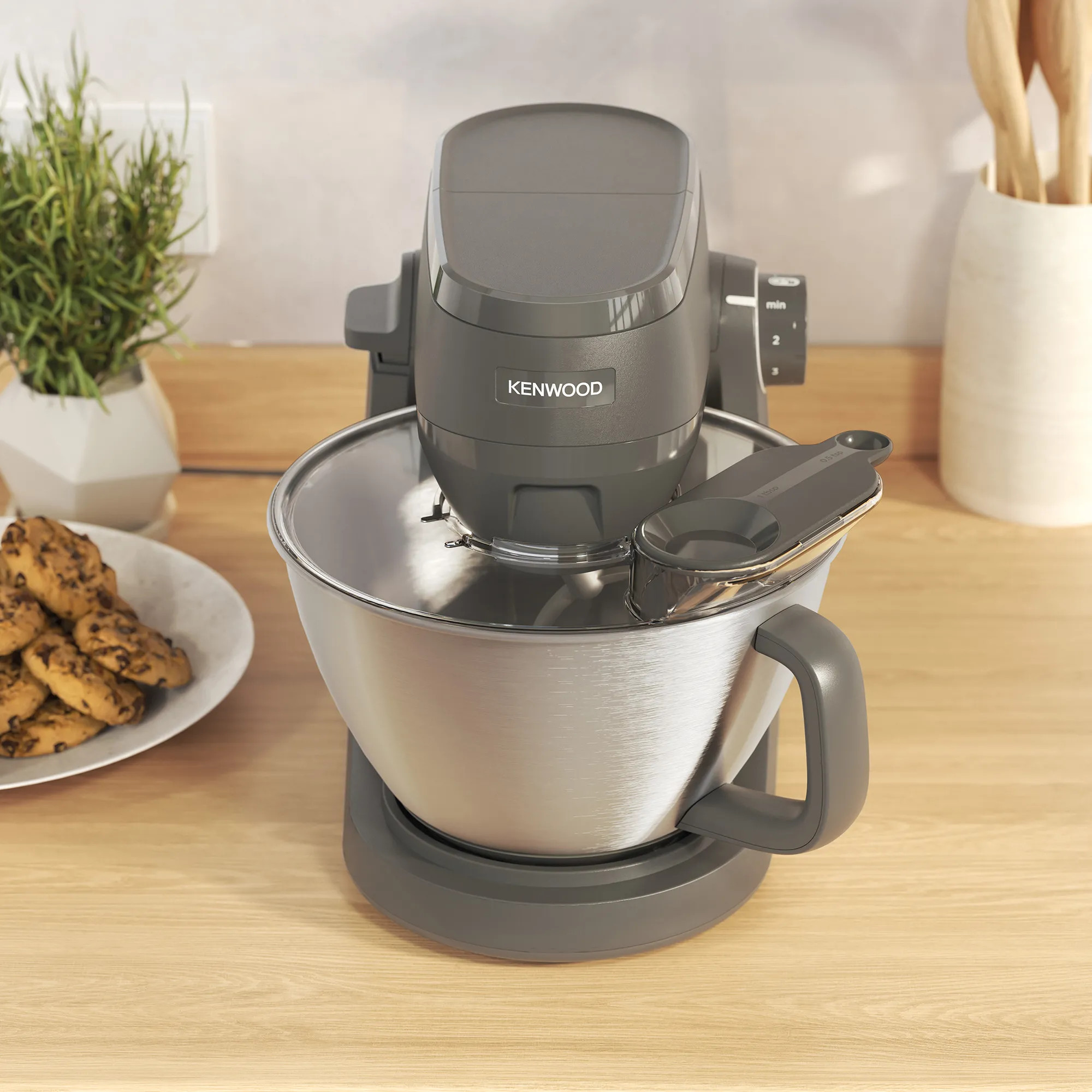Szara robot kuchenny Kenwood z misą ze stali nierdzewnej i ciasteczkami.