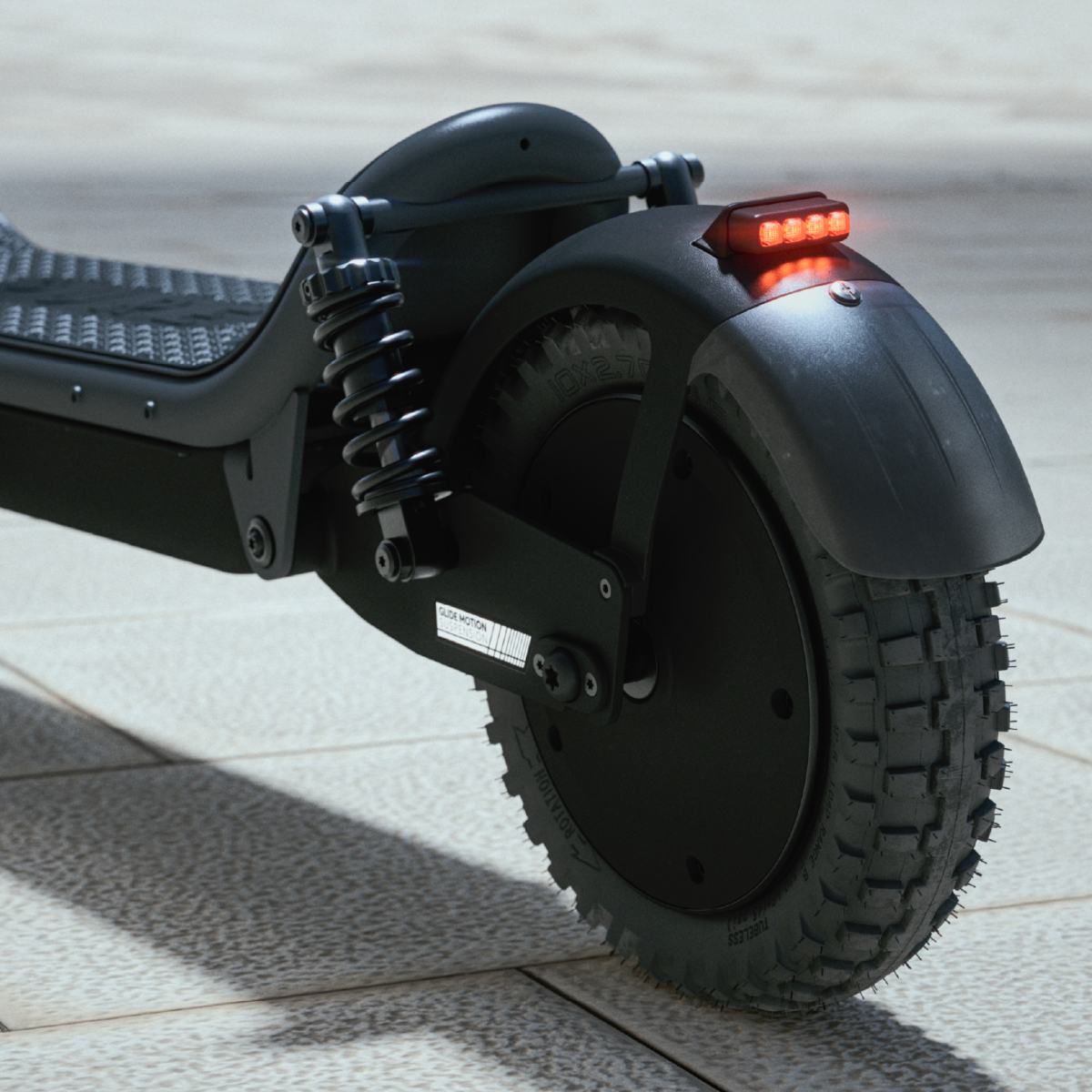 Schwarzes E-Scooter-Hinterrad, Kotflügel und Federungsdetail auf gepflastertem Boden.
