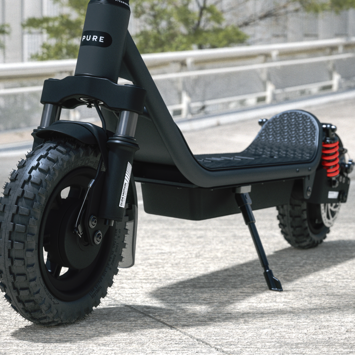 Ein schwarzer E-Scooter mit grobstolligen Reifen und roten Stoßdämpfern steht auf Beton.