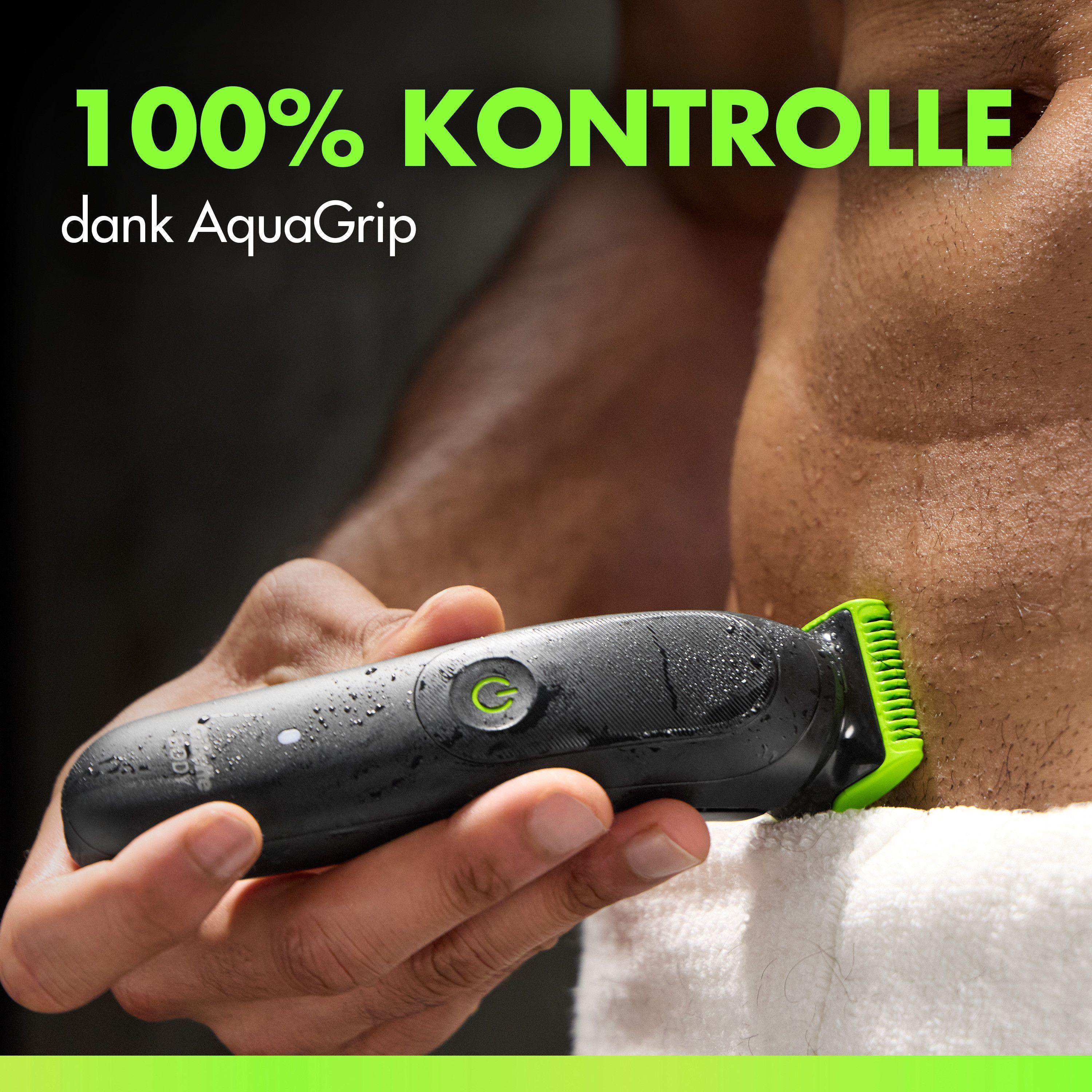 Ein Mann hält einen schwarzen Trimmer mit grüner Klinge. Wassertropfen auf dem Gerät.