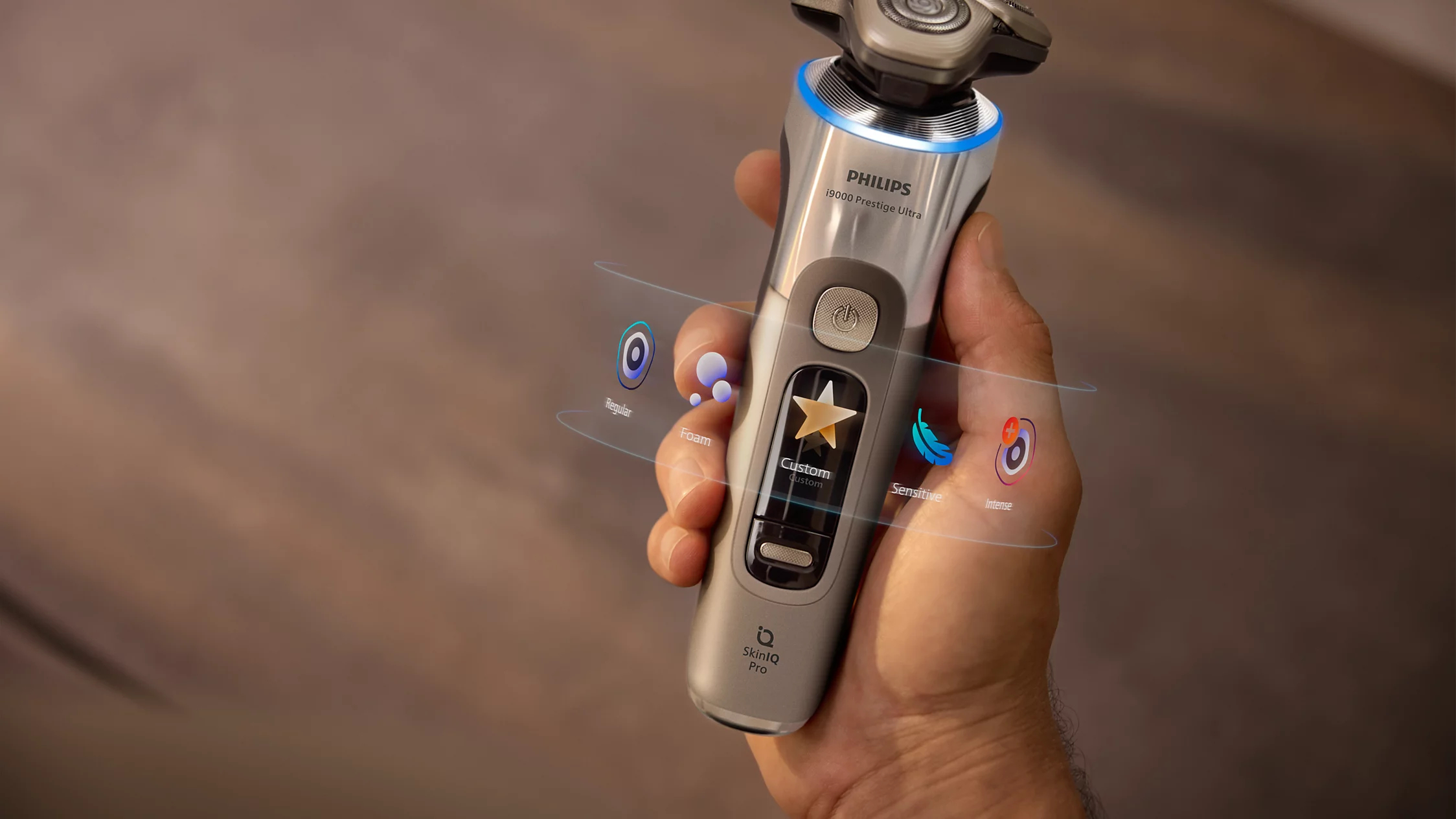 Dłoń trzyma golarkę Philips i9000 Prestige Ultra z holograficznymi wyświetlaczami trybów.