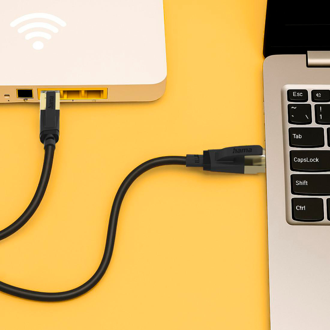 Ein schwarzes Ethernet-Kabel verbindet einen Router mit einem Laptop.