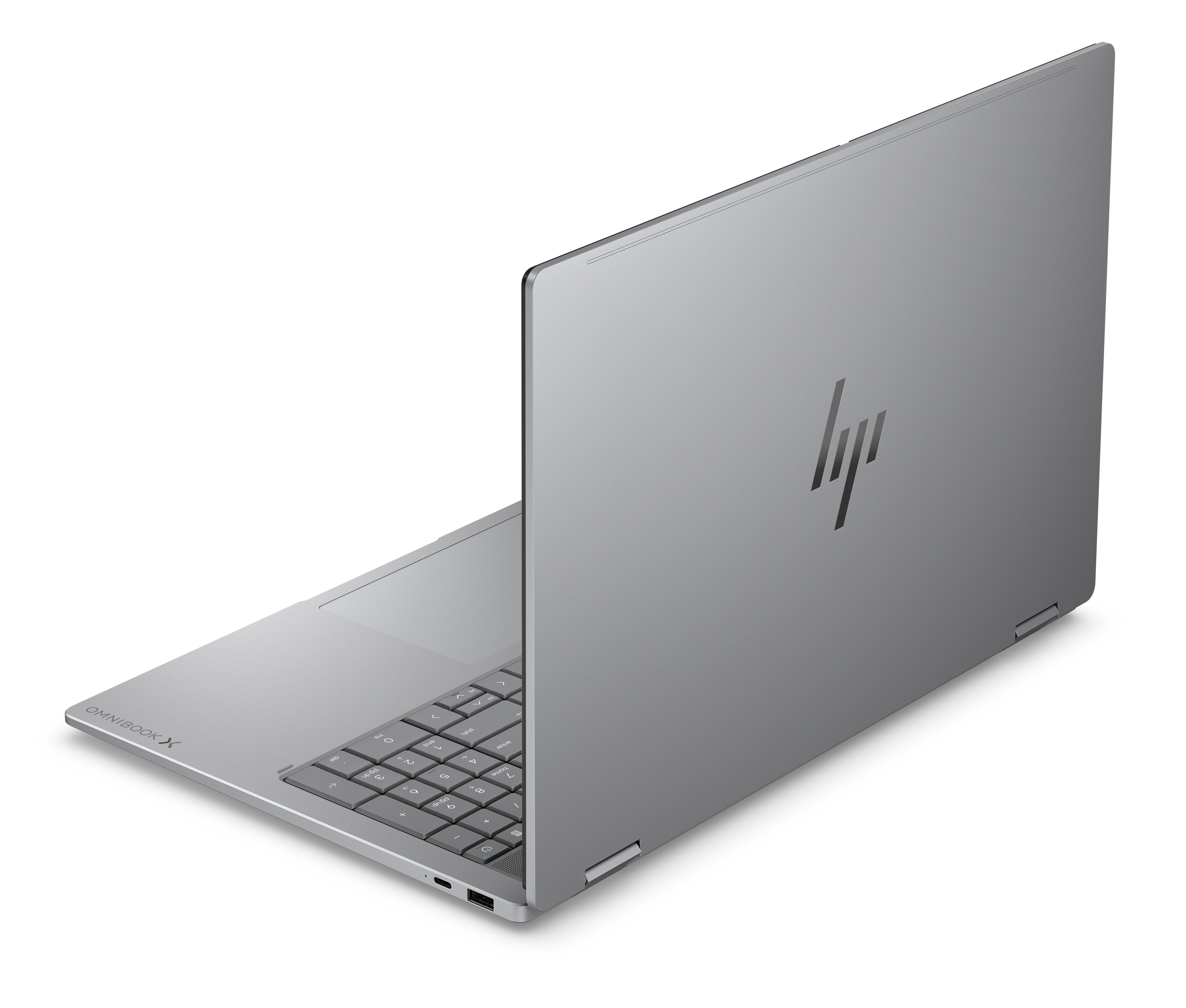 Srebrny laptop HP Omnibook jest otwarty, widać klawiaturę i logo HP.