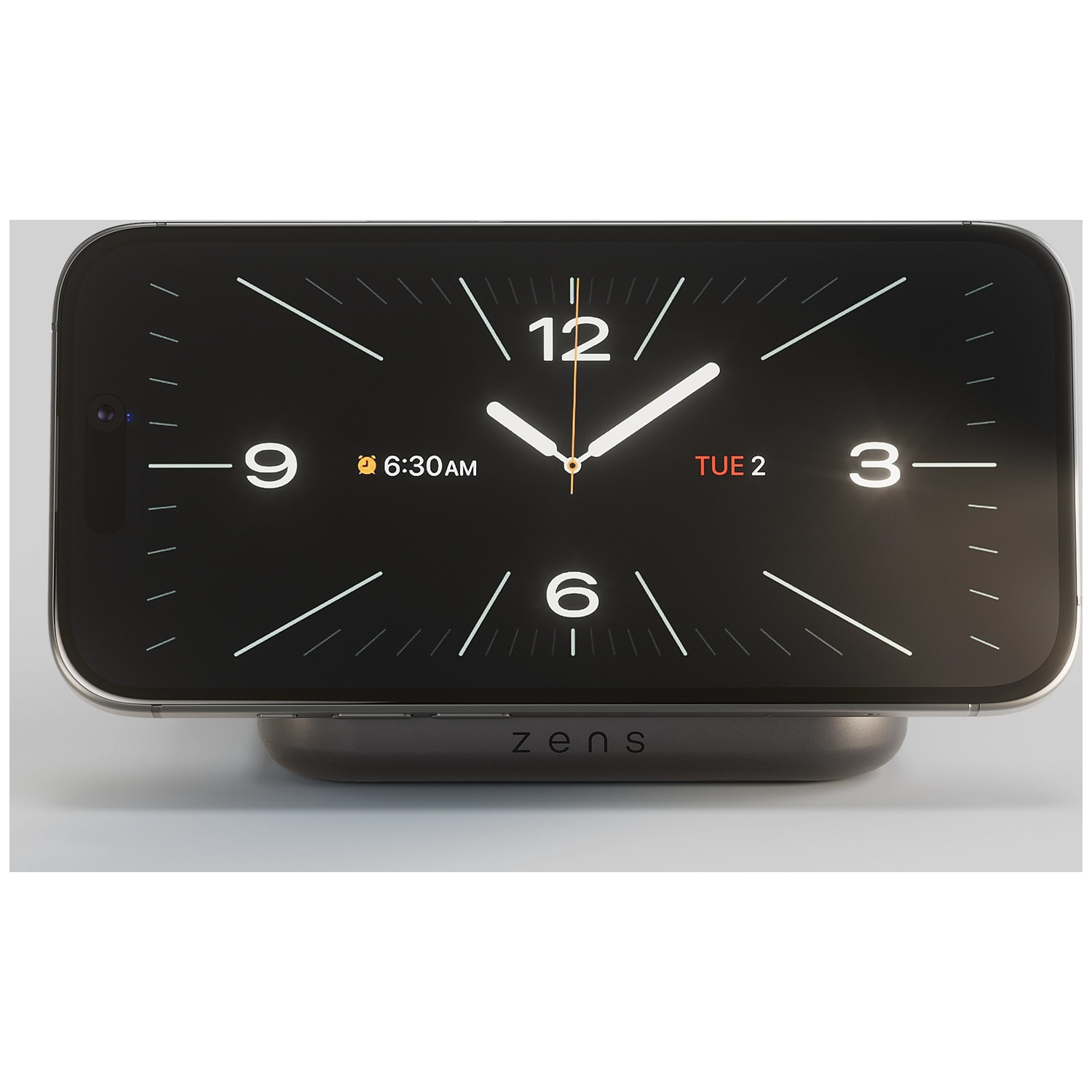 A smartphone with a black clock face rests on a charging stand.
