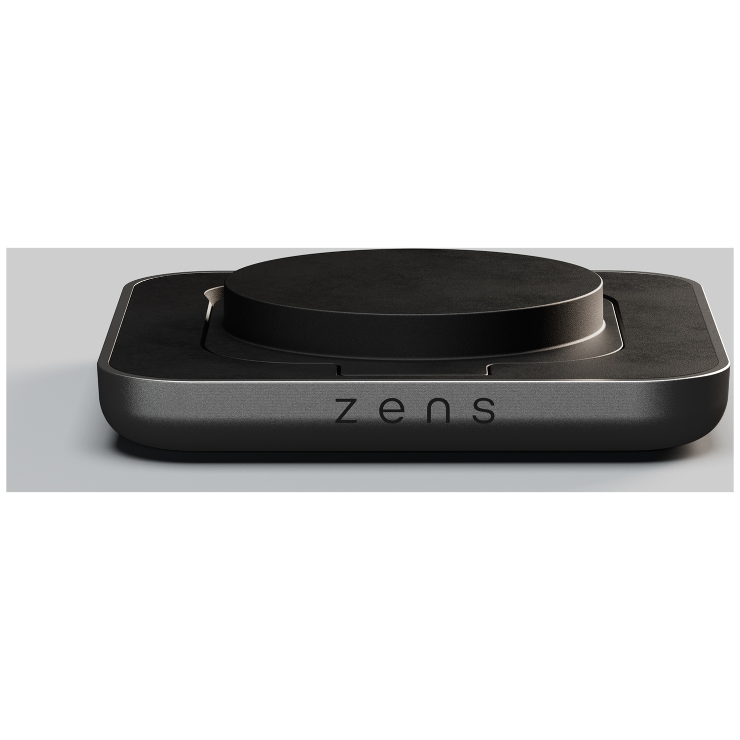 A black rectangular charging pad with a circular raised center, displaying the Zens logo on its front edge.