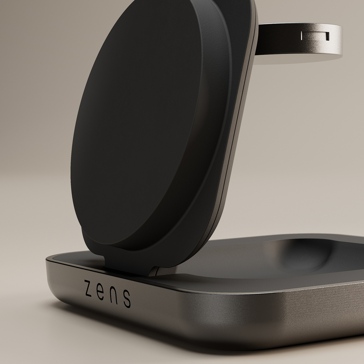 A close-up shot of a black and silver Zens charging stand with a circular pad angled upwards, against a light background.