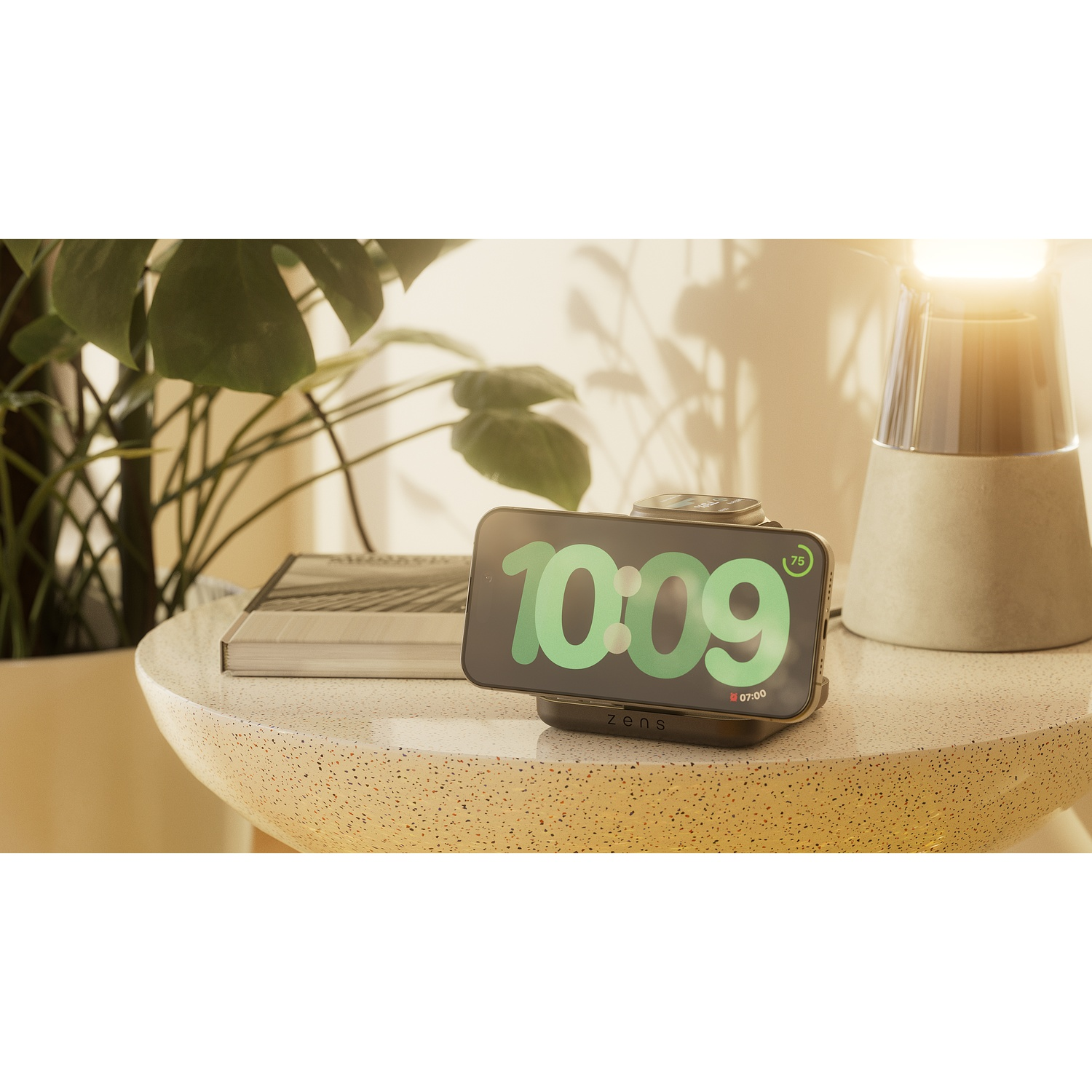 A smartphone on a black wireless charger displays "10:09" in green text, with a plant and lamp in the background.