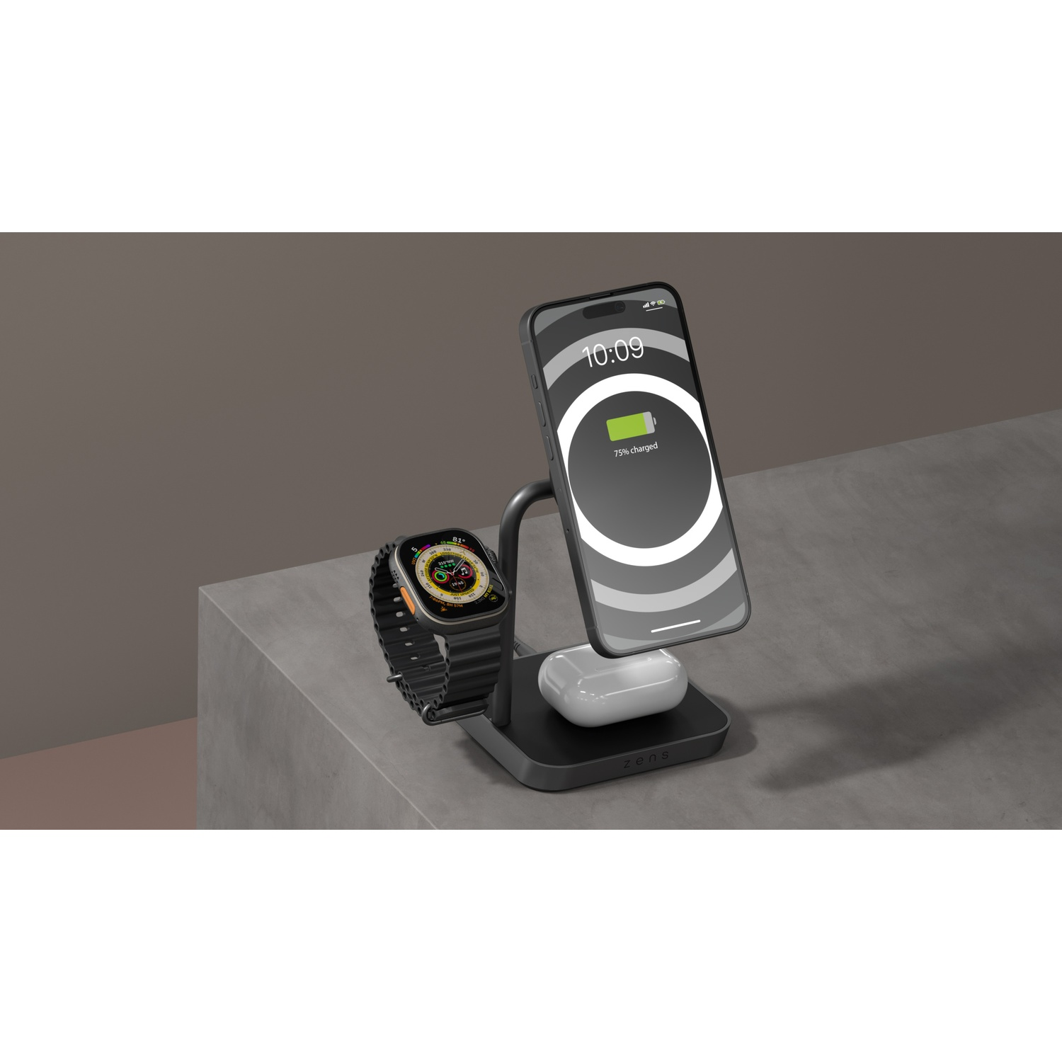 A black multi-device charger powers a phone, smartwatch, and earbuds on a gray surface against a dark background.