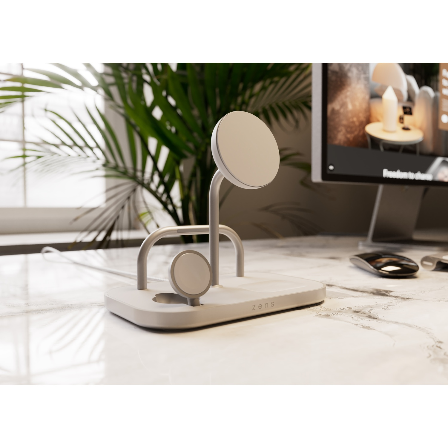 A white charger for smartphones and watches sits on a marble desk beside a computer.