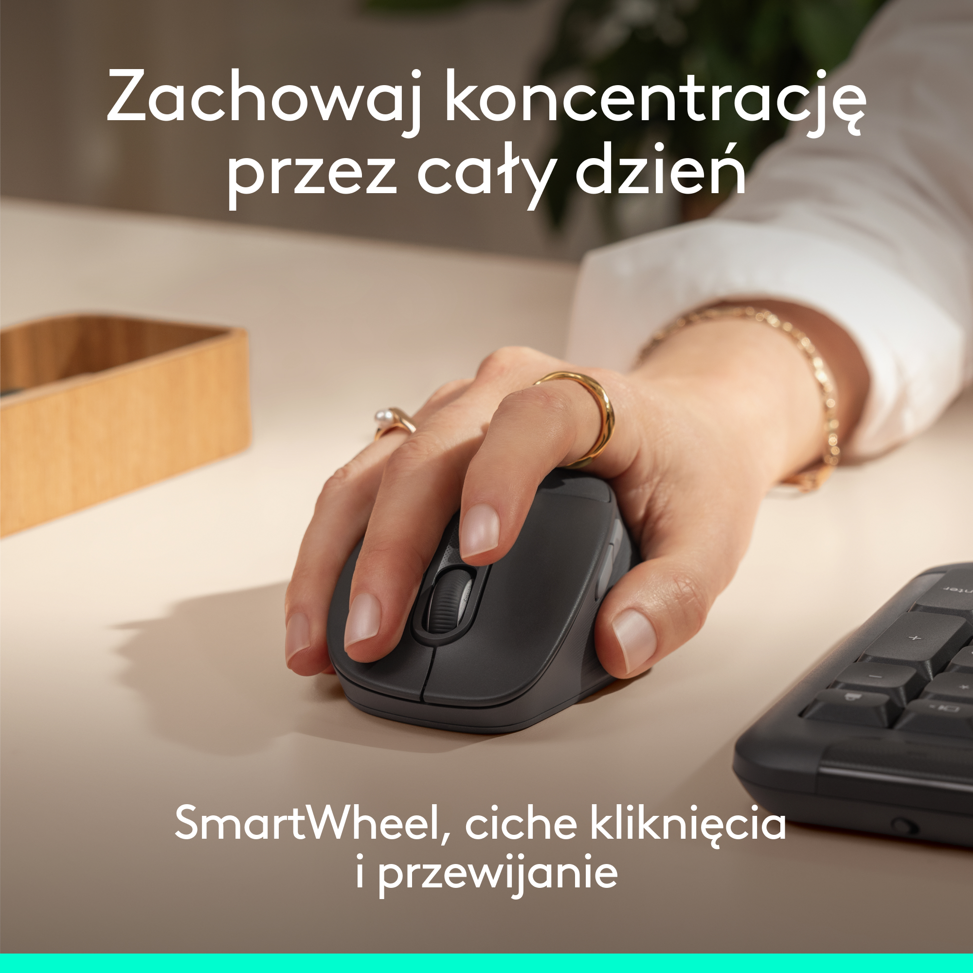 Dłoń obsługuje ciemną mysz komputerową. Po prawej widać klawiaturę.