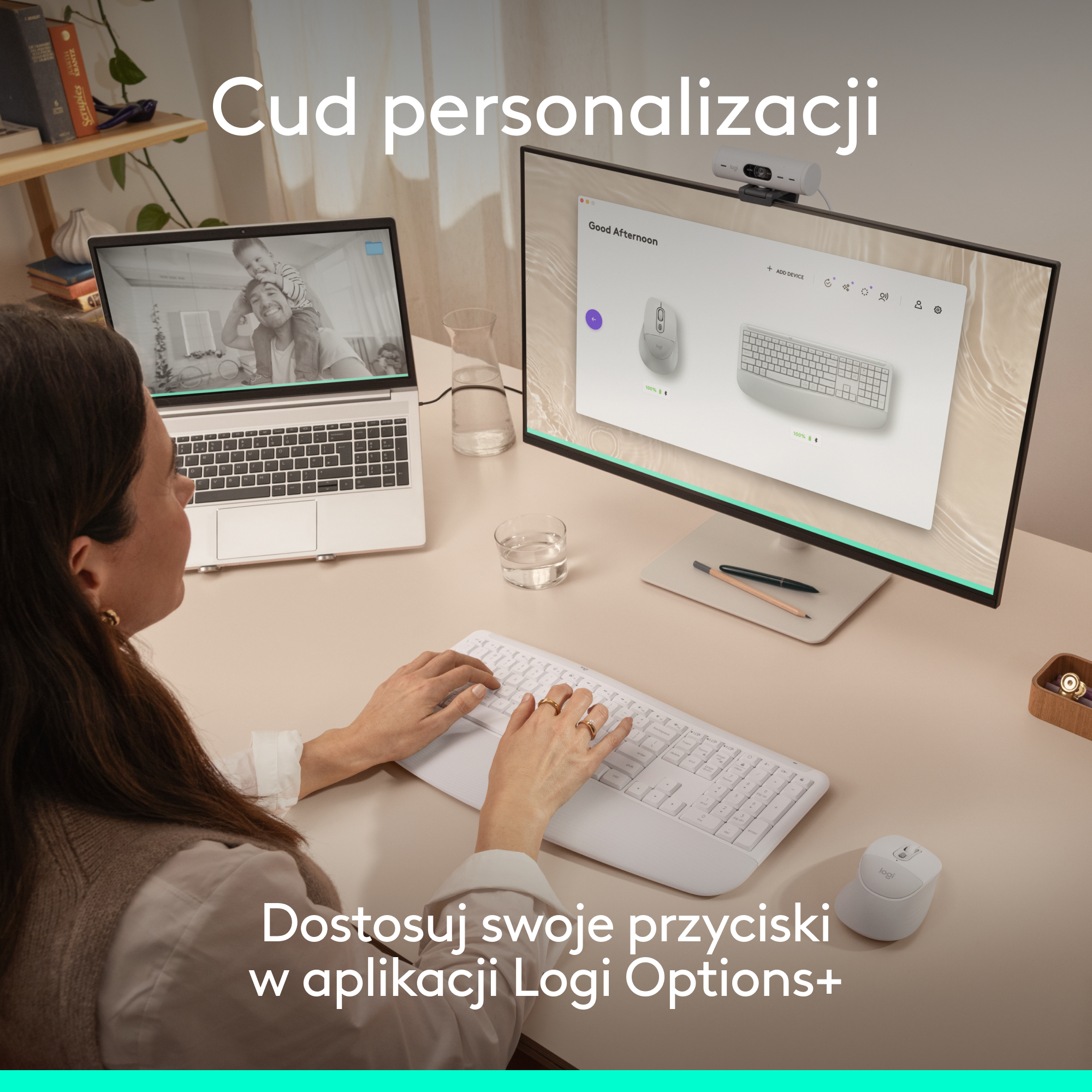 Osoba pisze na klawiaturze, widoczny laptop i monitor.