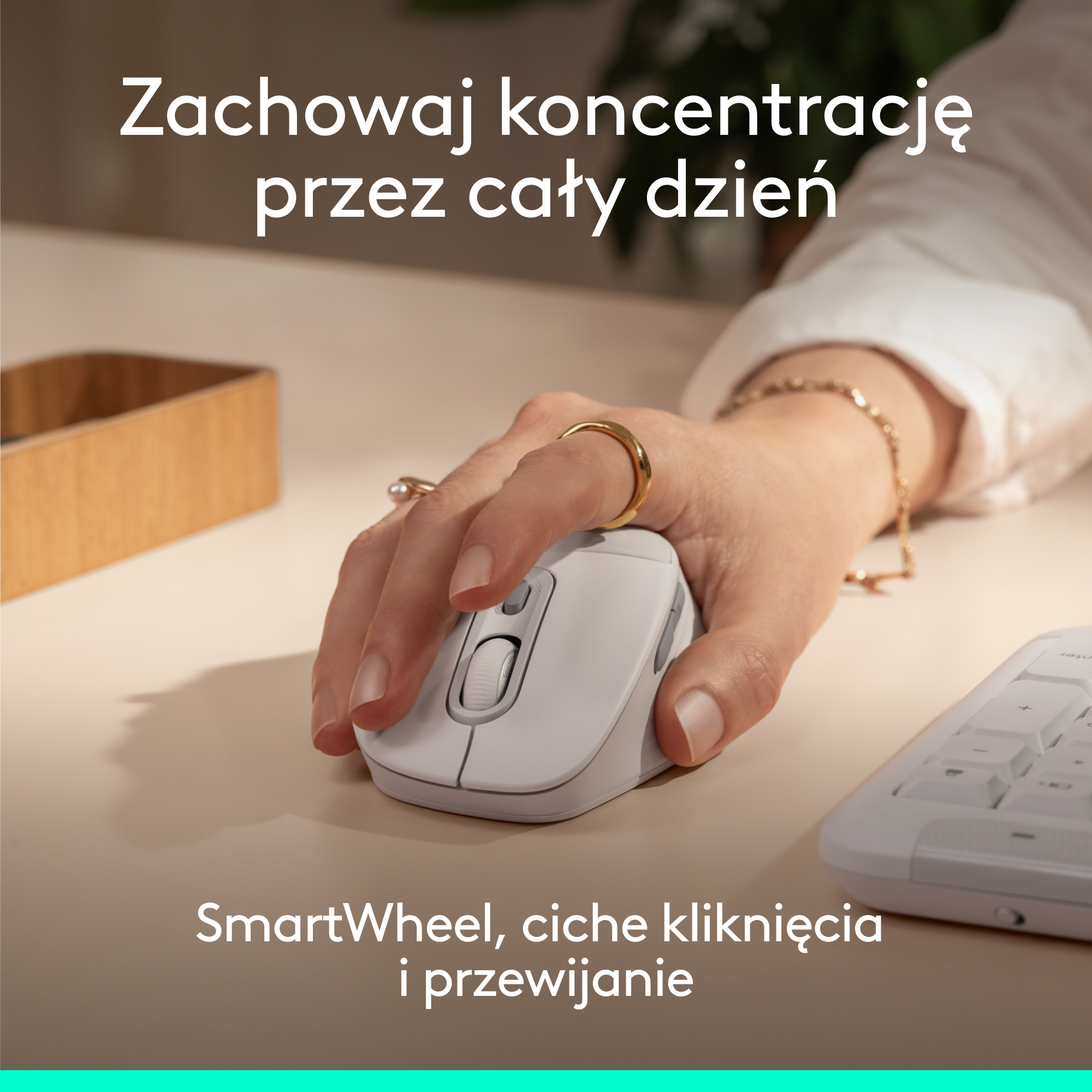 Dłoń obsługuje białą mysz na biurku. Klawiatura i pojemnik w tle.