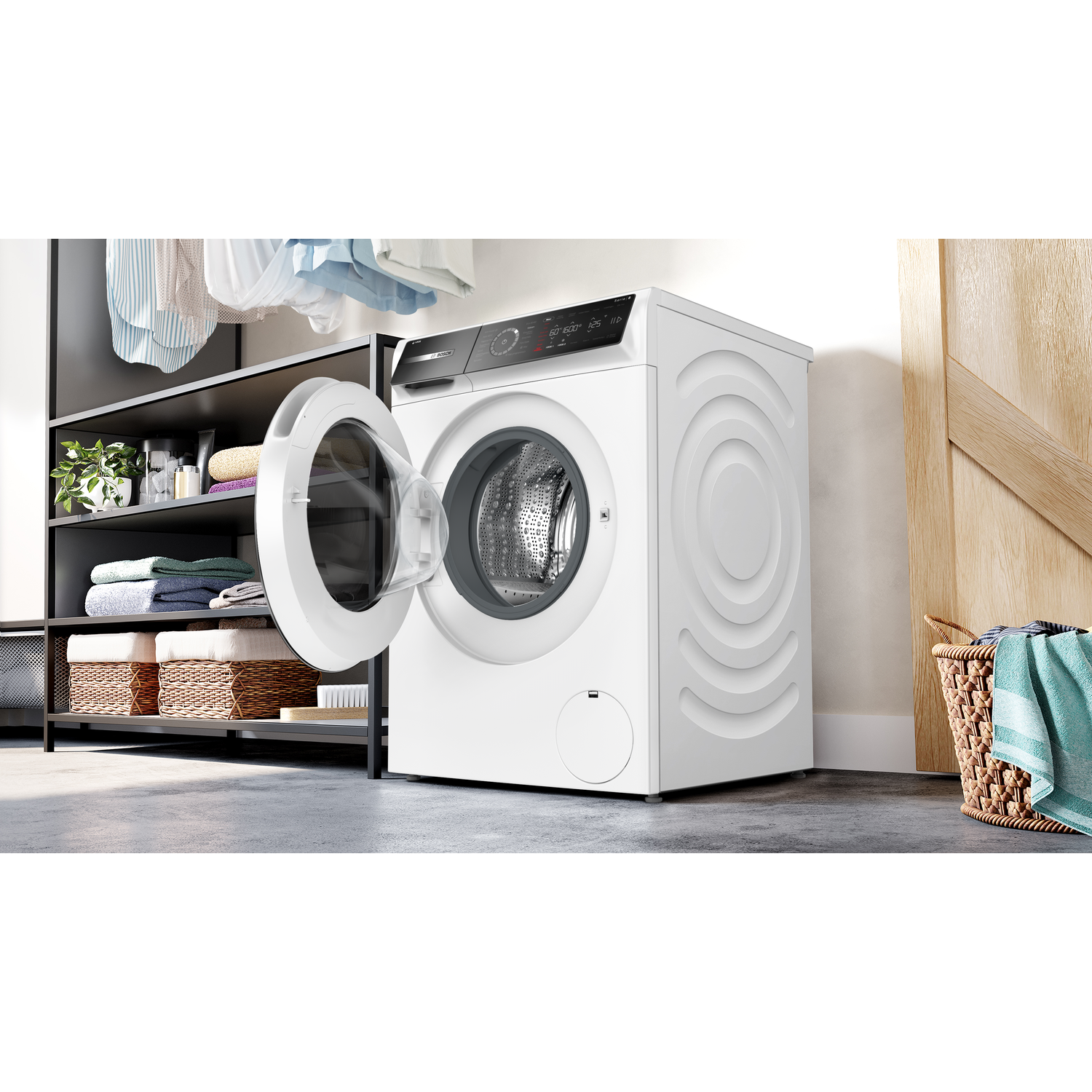 Witte wasmachine met open deur naast planken met wasgoed en een wasmand.