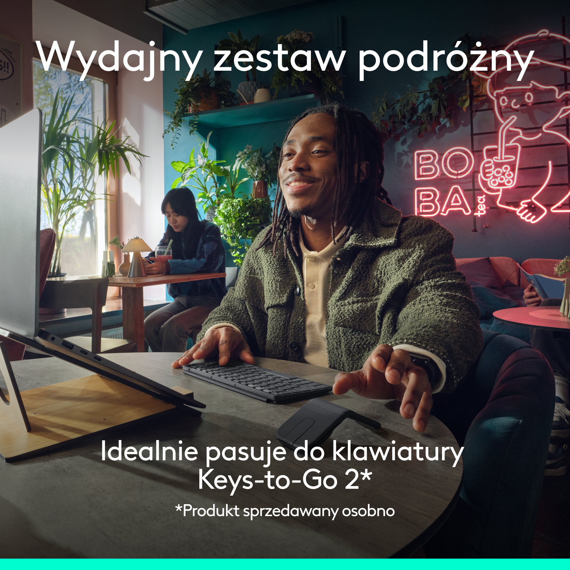 Mężczyzna pisze na klawiaturze w kawiarni. Neonowe światła w tle.
