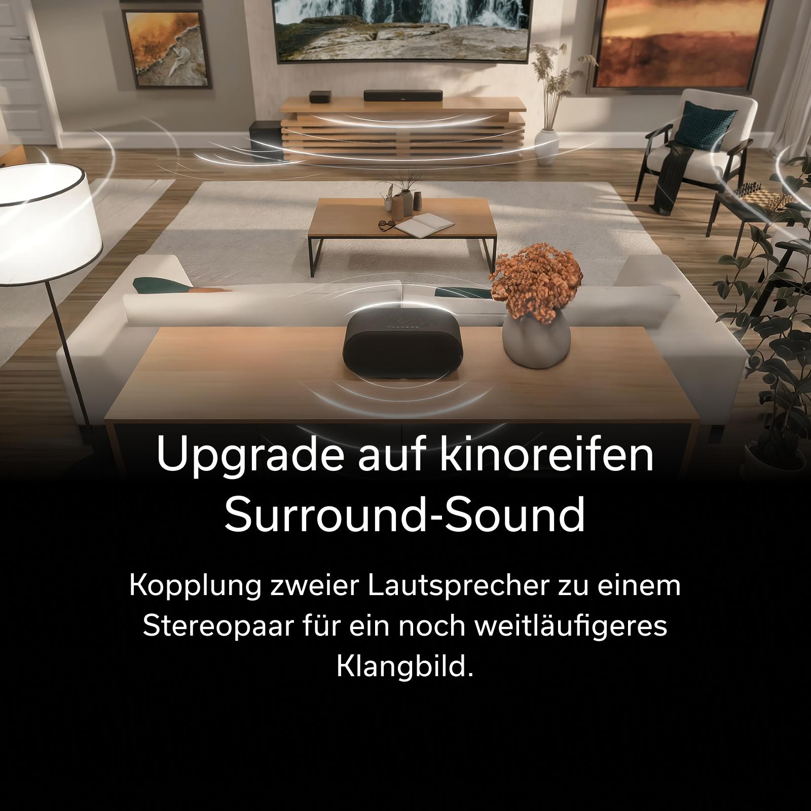 Ein schwarzer Lautsprecher steht auf einem Tisch in einem Wohnzimmer.
