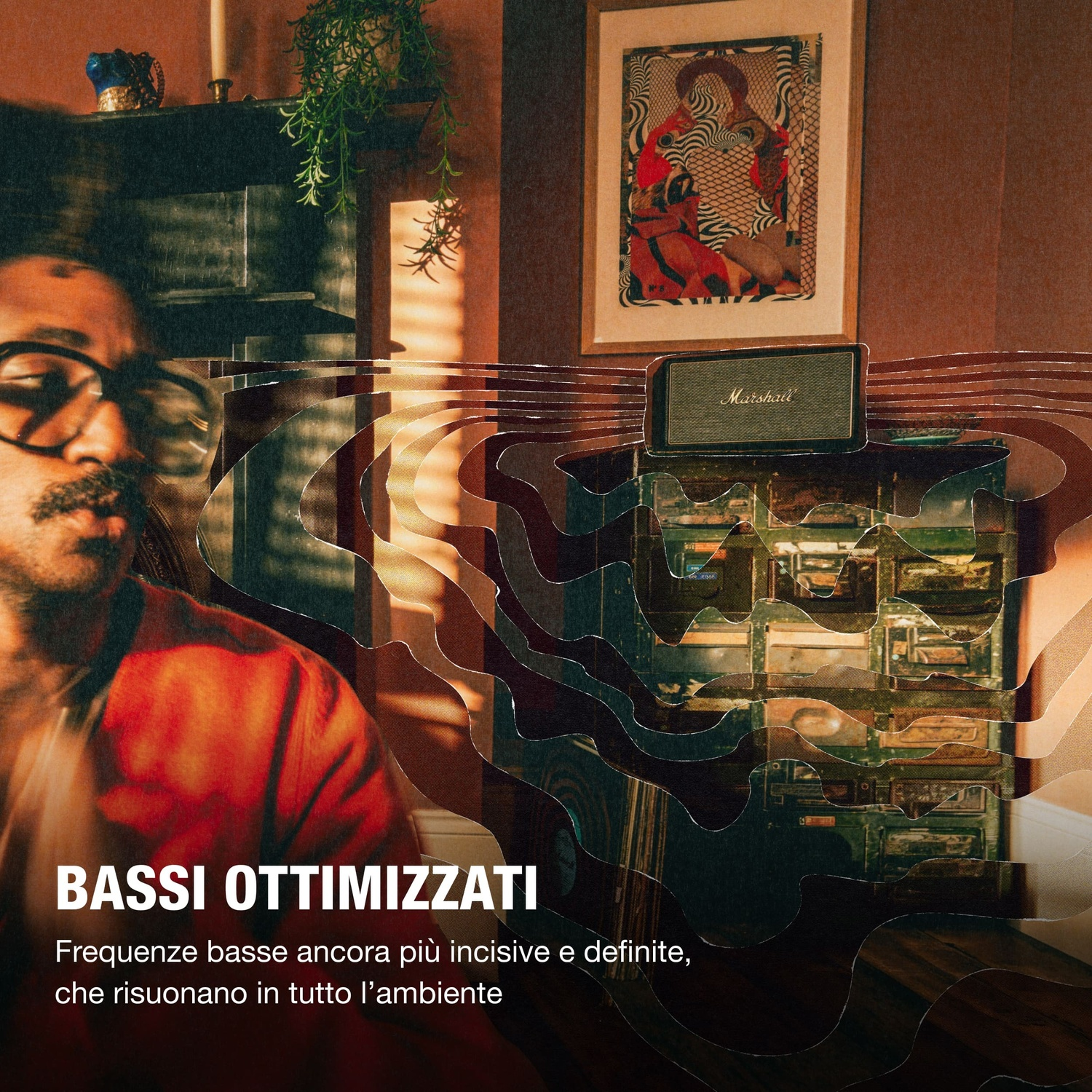 Uomo con occhiali davanti a cassa Marshall e quadro. "BASSI OTTIMIZZATI"
