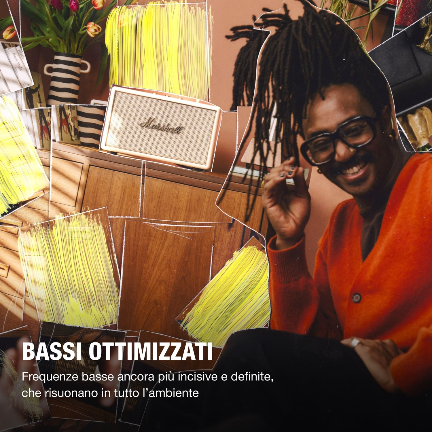 Un uomo con dreadlocks e occhiali sorride, accanto a uno speaker Marshall.