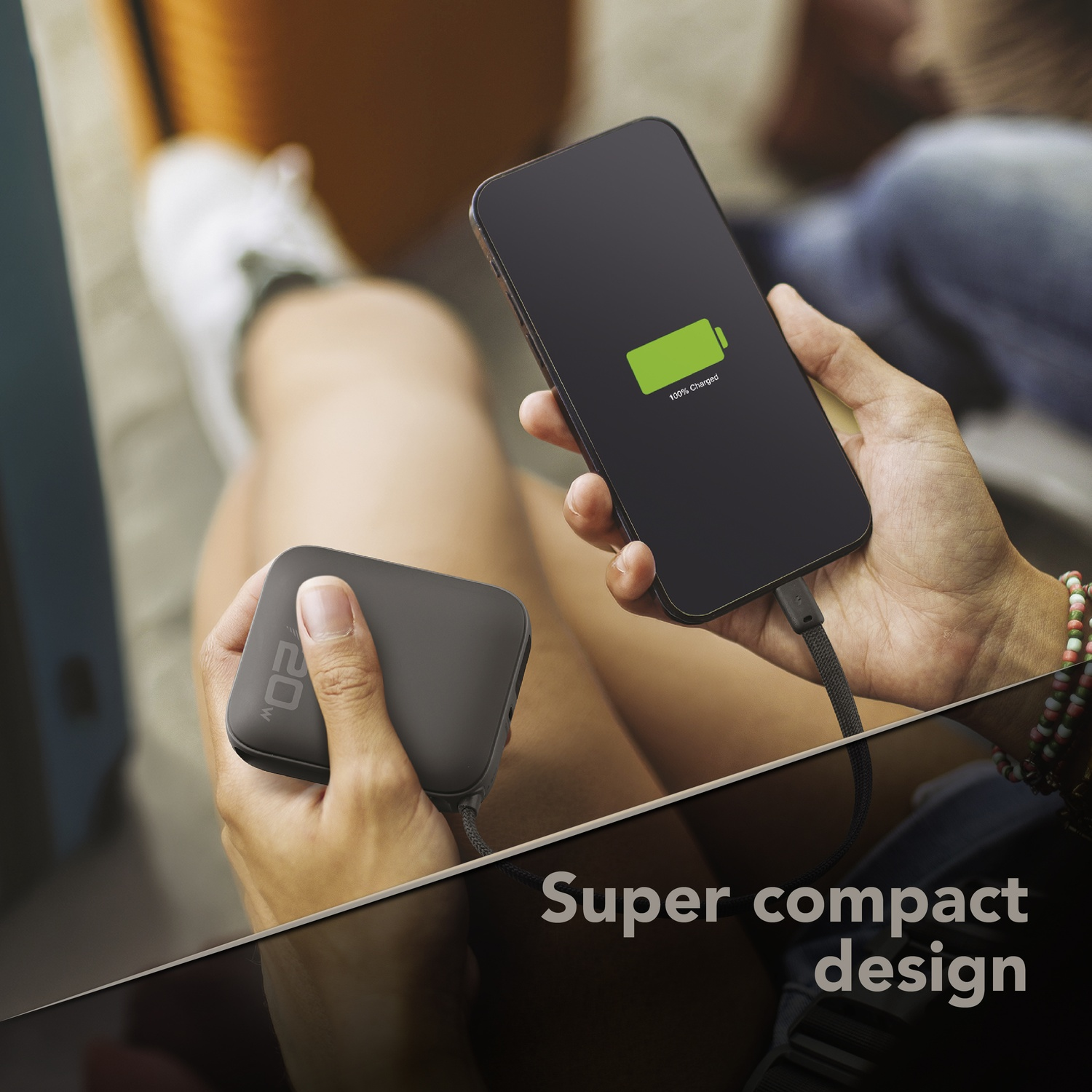 Una persona carica il suo smartphone con un power bank compatto.