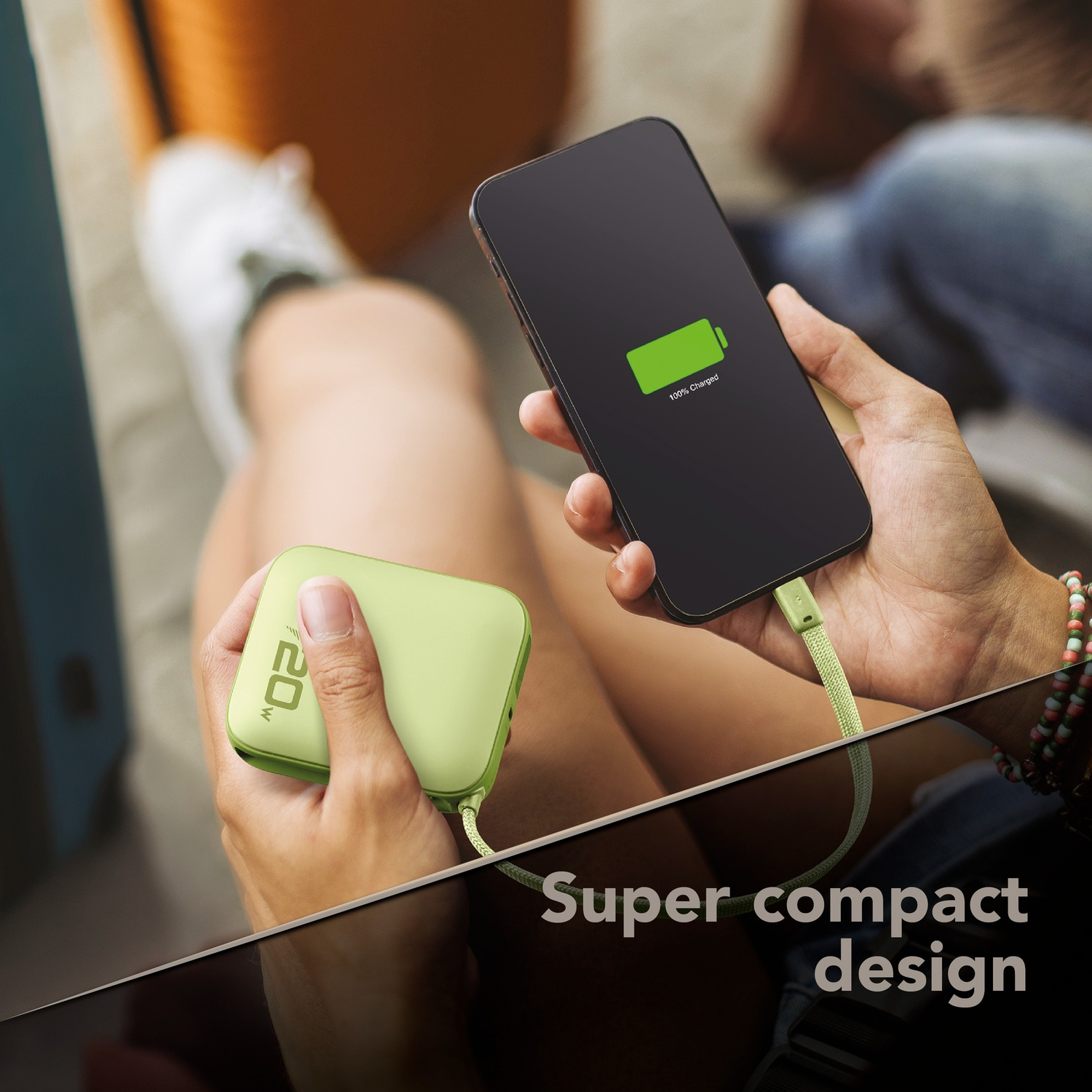 Una persona carica un telefono con un power bank verde.