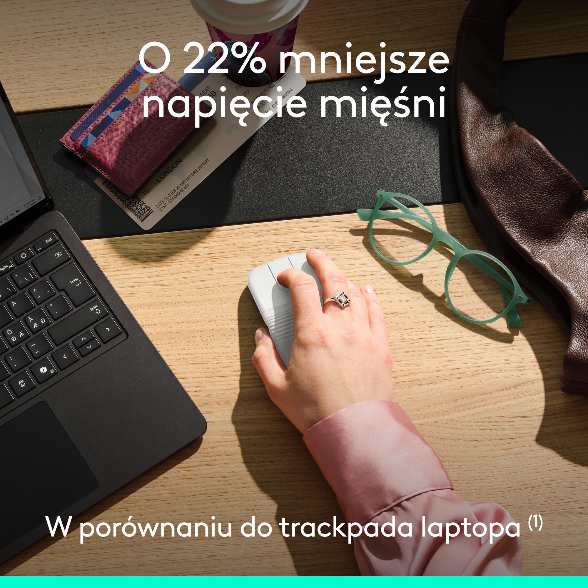 Osoba używa białej myszy komputerowej na drewnianym biurku obok laptopa, okularów i dokumentów podróżnych.
