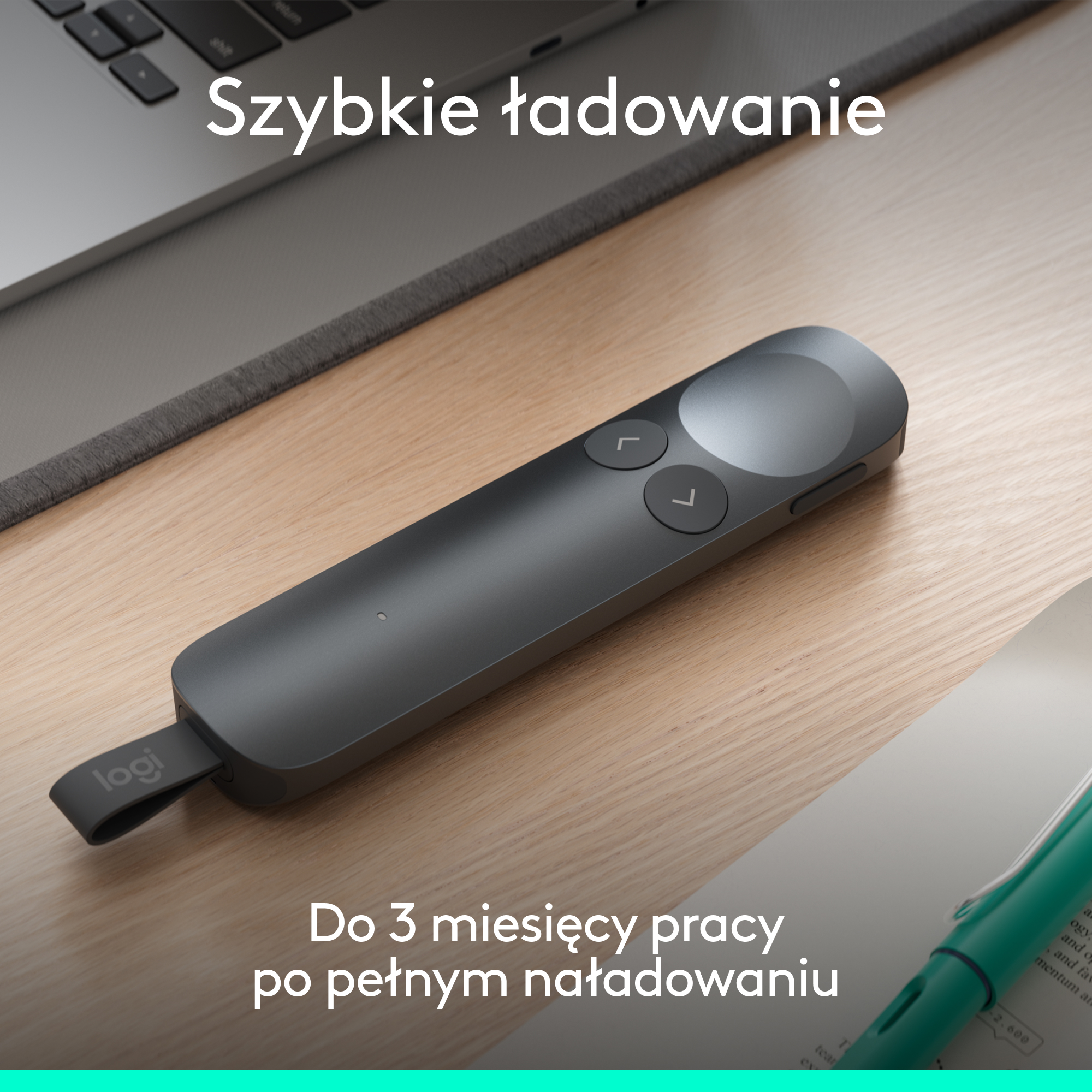Szary pilot Logitech do prezentacji leży na drewnianym biurku obok laptopa i książki.