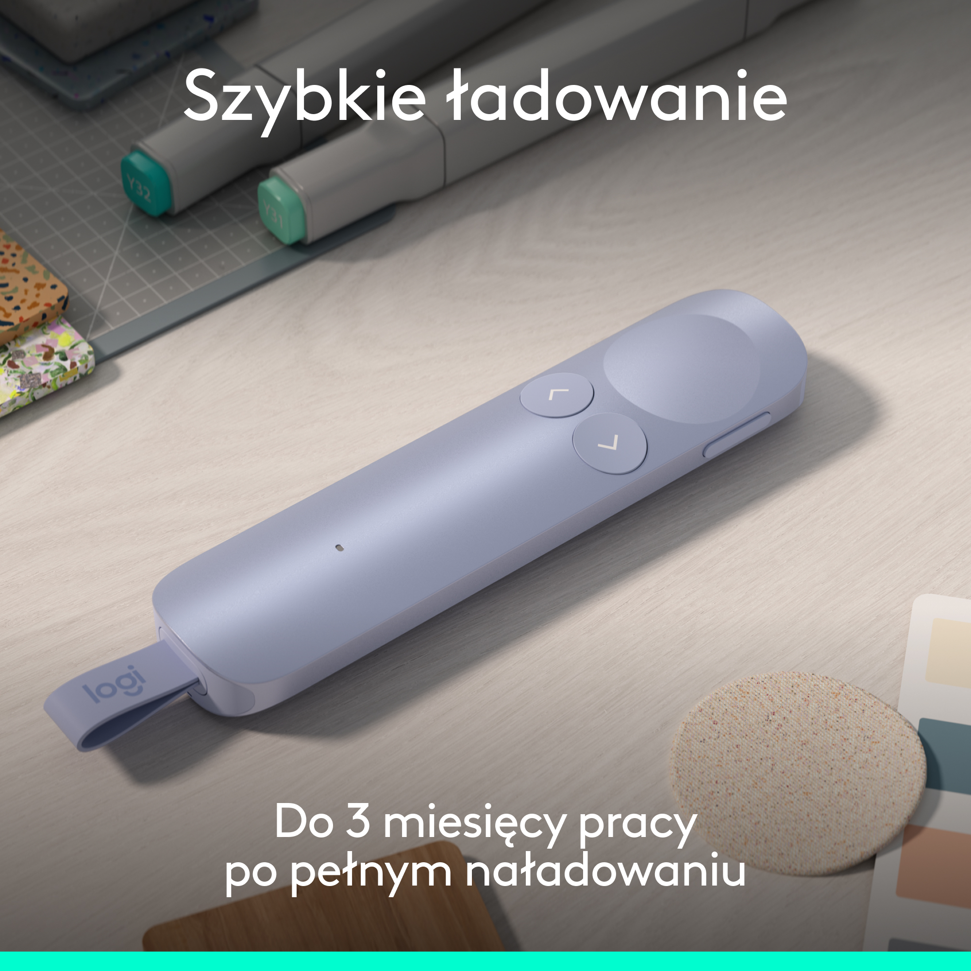 Fioletowy wskaźnik Logitech z dwoma przyciskami leży na drewnianym stole obok markerów.