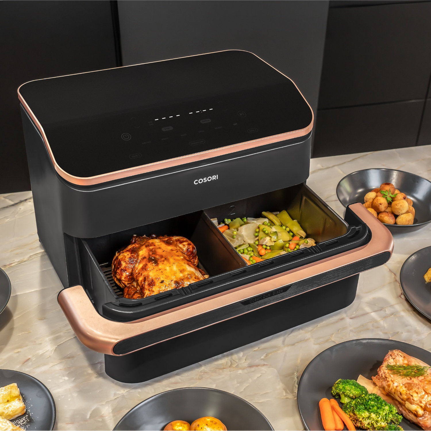 Friggitrice Cosori noire avec accents de cuivre, contenant un poulet et des légumes.