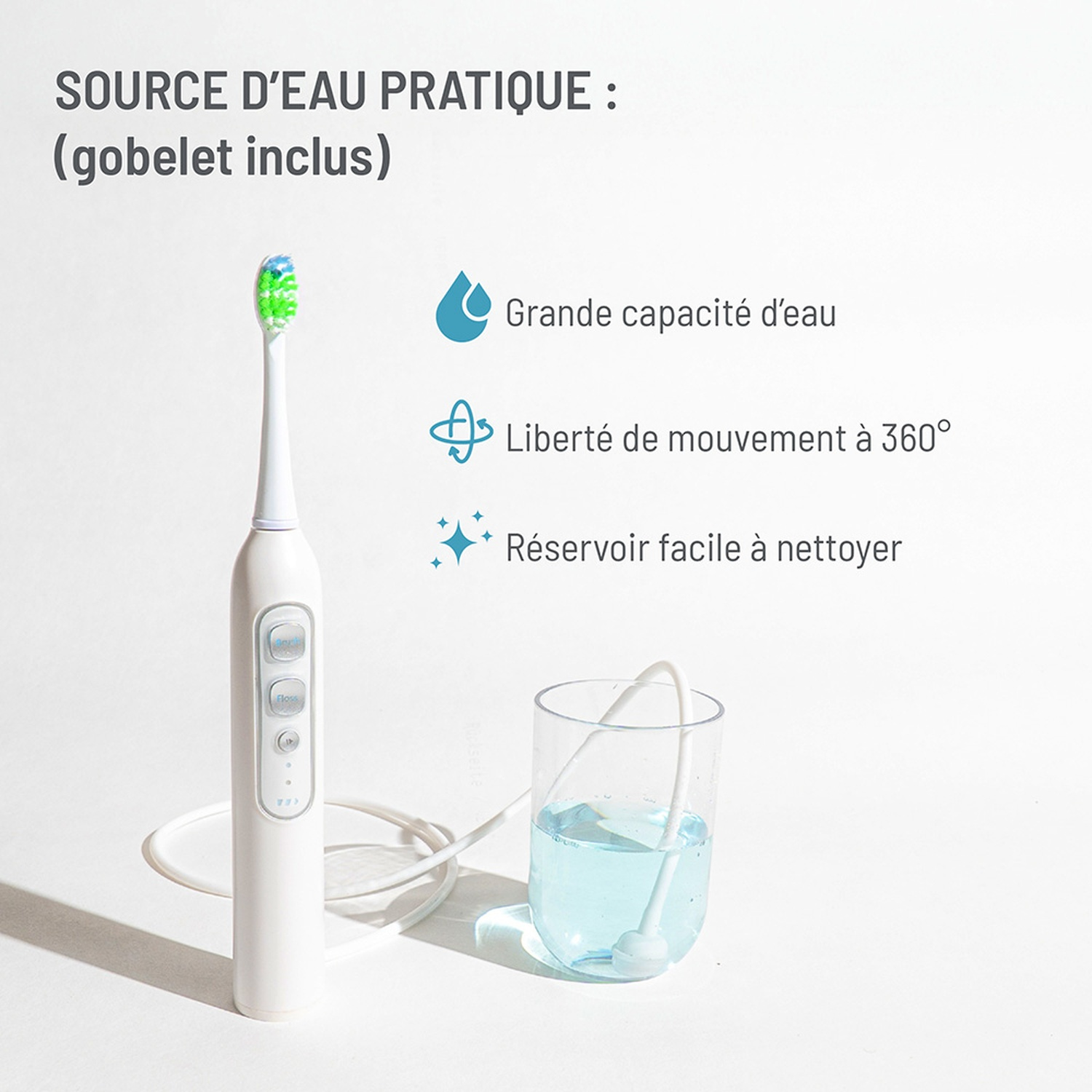 White electric toothbrush next to a glass of blue liquid with a tube.