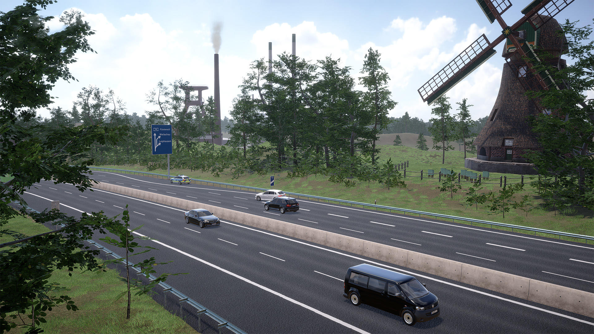Eine Luftaufnahme einer mehrspurigen Autobahn mit Autos, einem blauen Schild, einem Industriekomplex und einer Windmühle an einem sonnigen Tag.