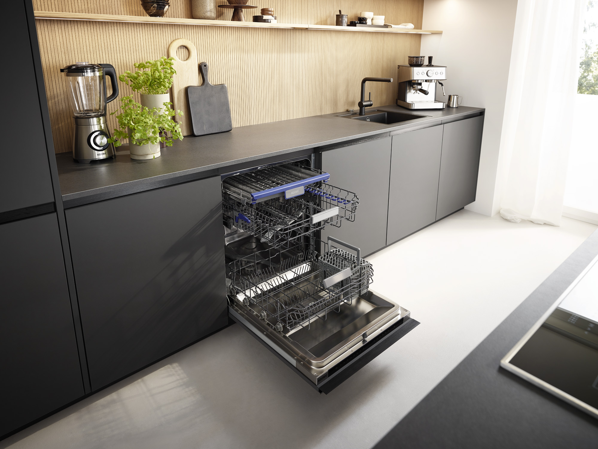 Eine moderne Küche mit dunkelgrauen Schränken, einer schwarzen Arbeitsplatte und einem geöffneten Geschirrspüler. Ein Mixer und Pflanzen stehen auf der Arbeitsplatte.