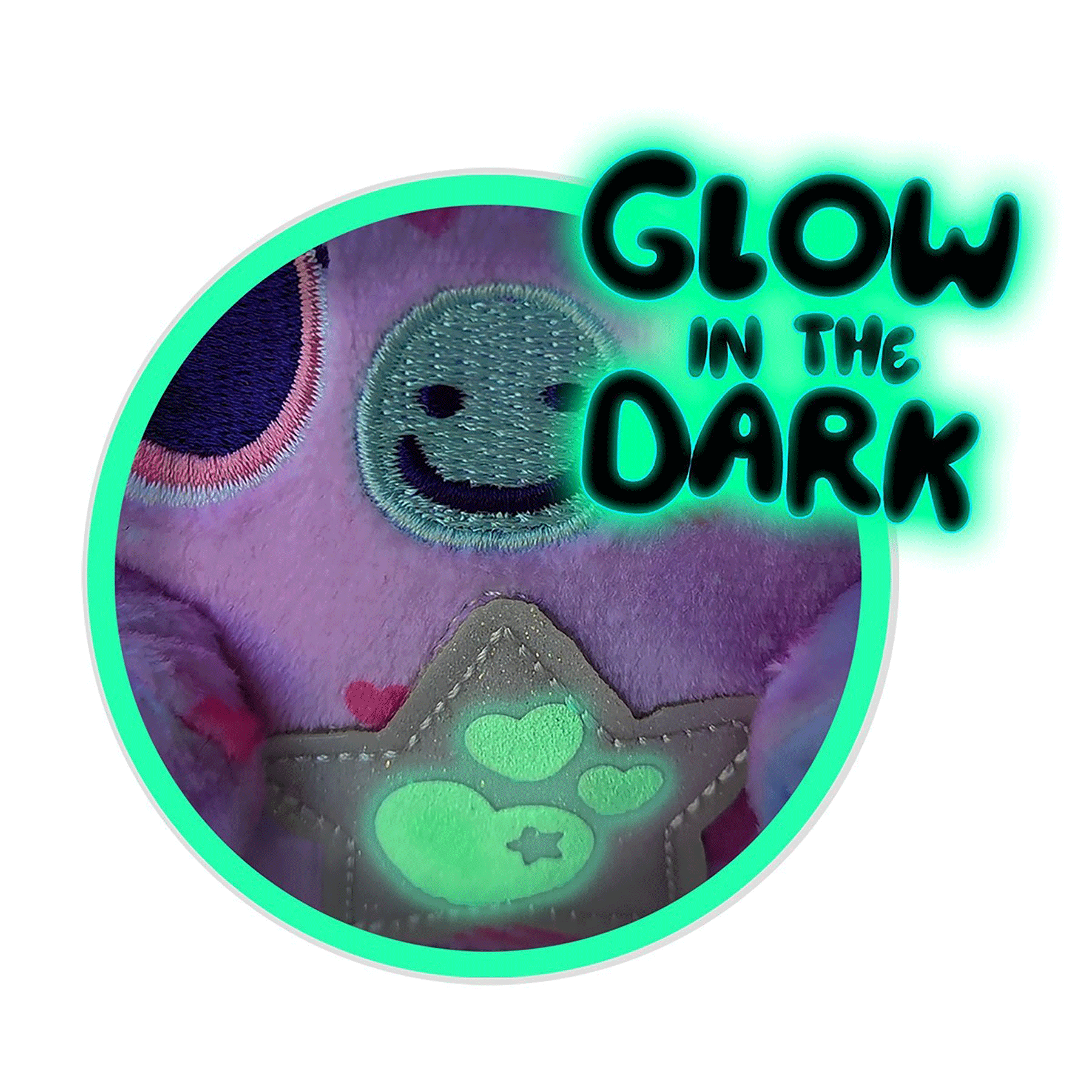 Lila plüssjáték világító mancsokkal és mosolygós arccal. "GLOW IN THE DARK" felirat.
