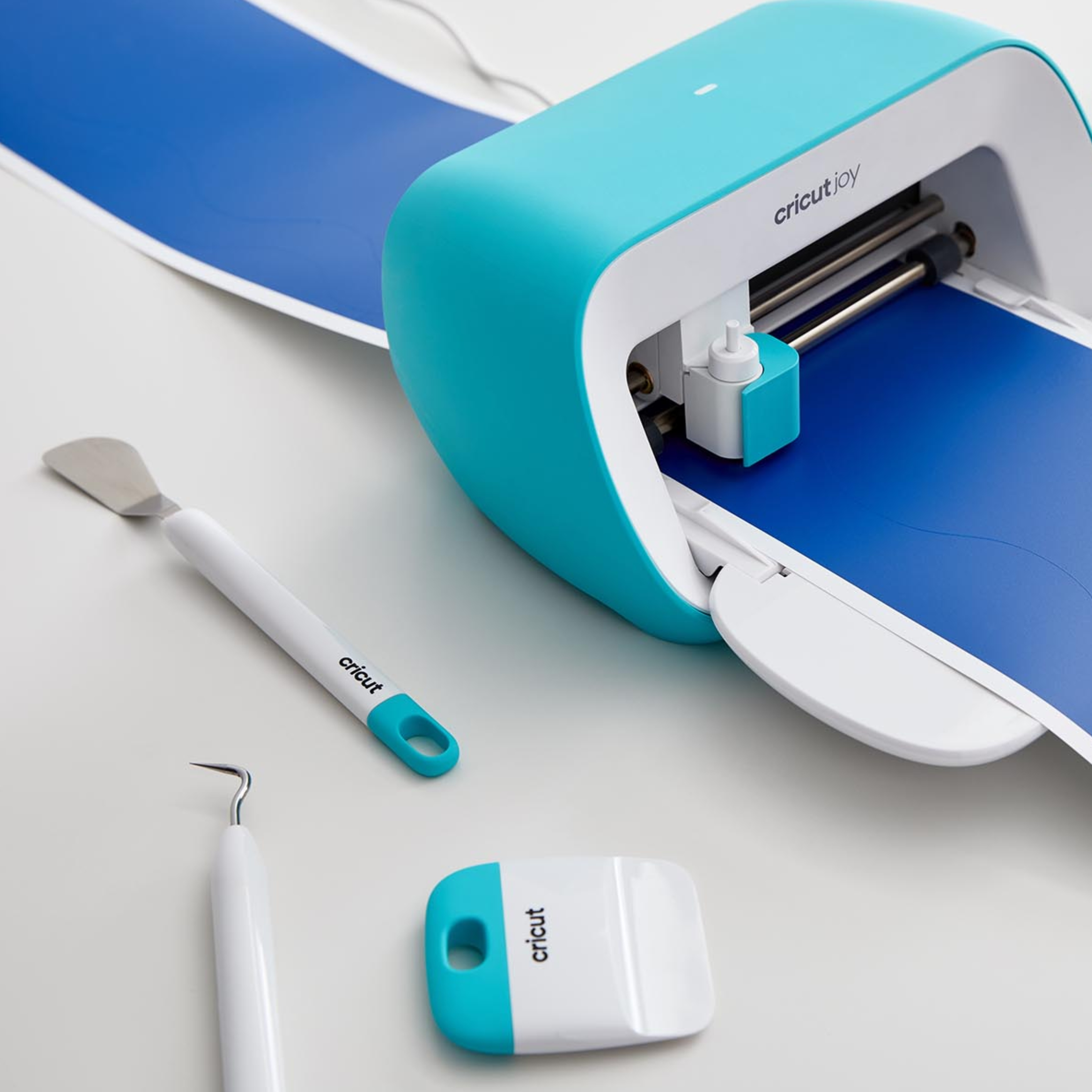 Mavi vinil ve aletlerle teal Cricut Joy kesme makinesi.